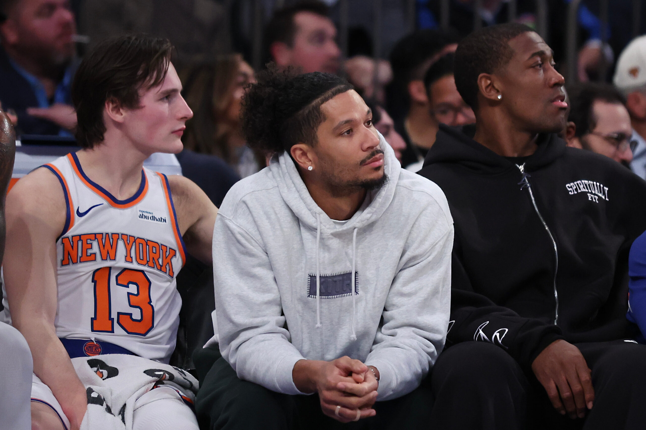 Injured New York Knicks guard Josh Hart, center, sits on...