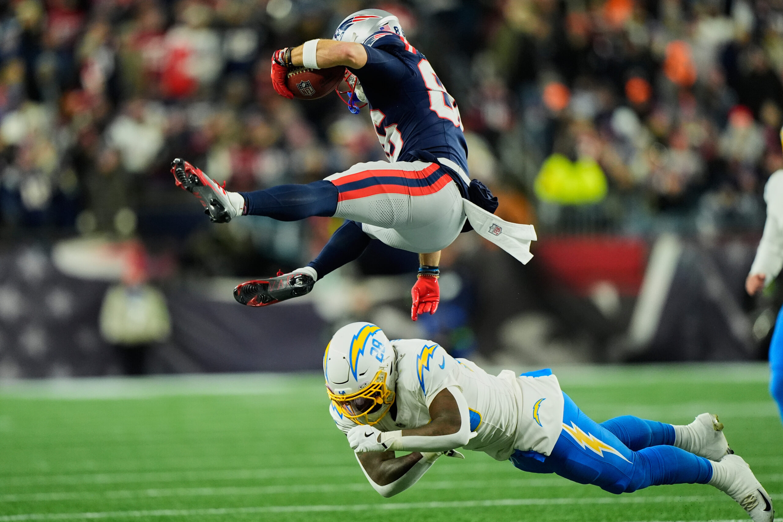 New England Patriots’ Efton Chism III, top, is upended by...
