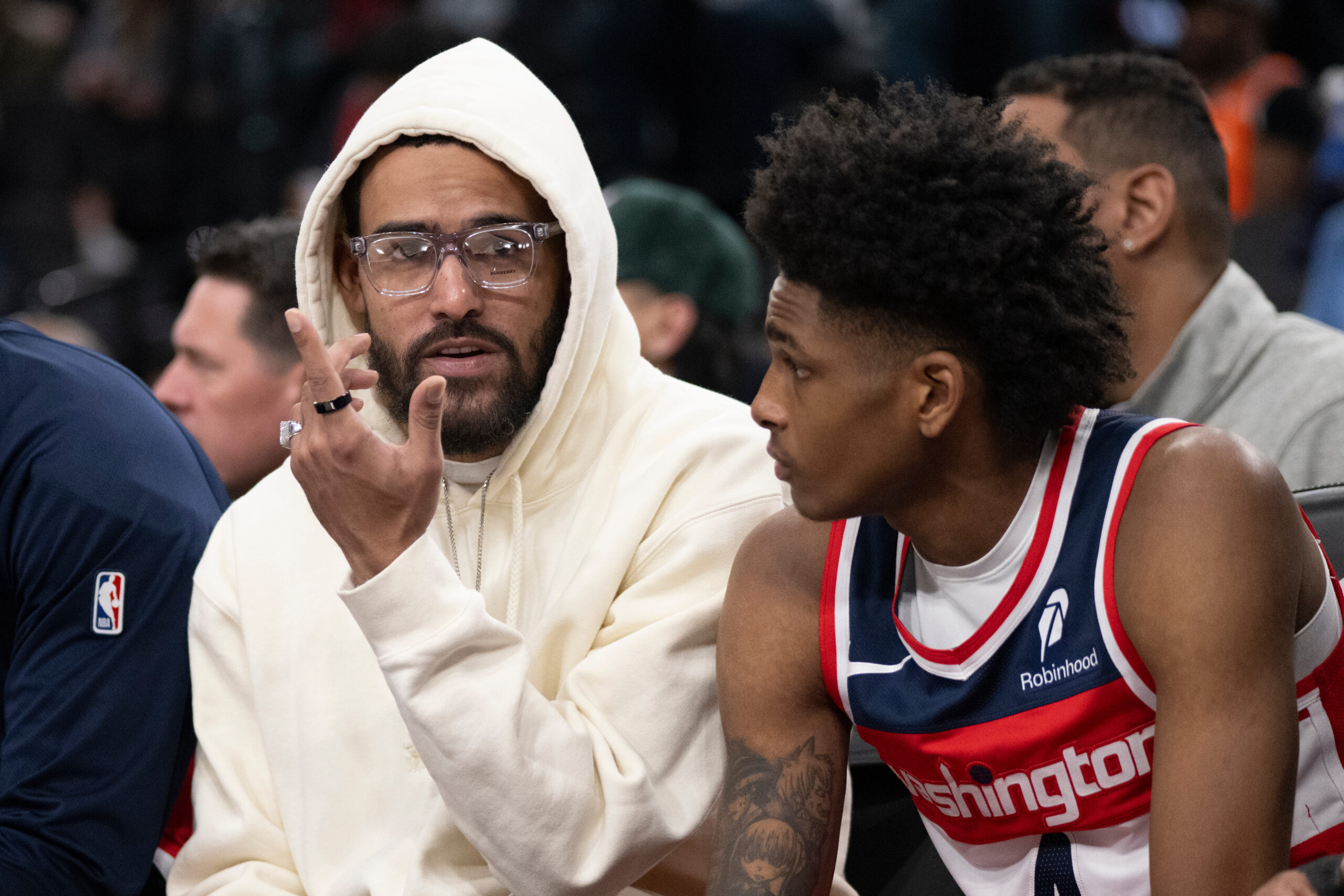 Injured Washington Wizards guard Trae Young, left, talks to guard...