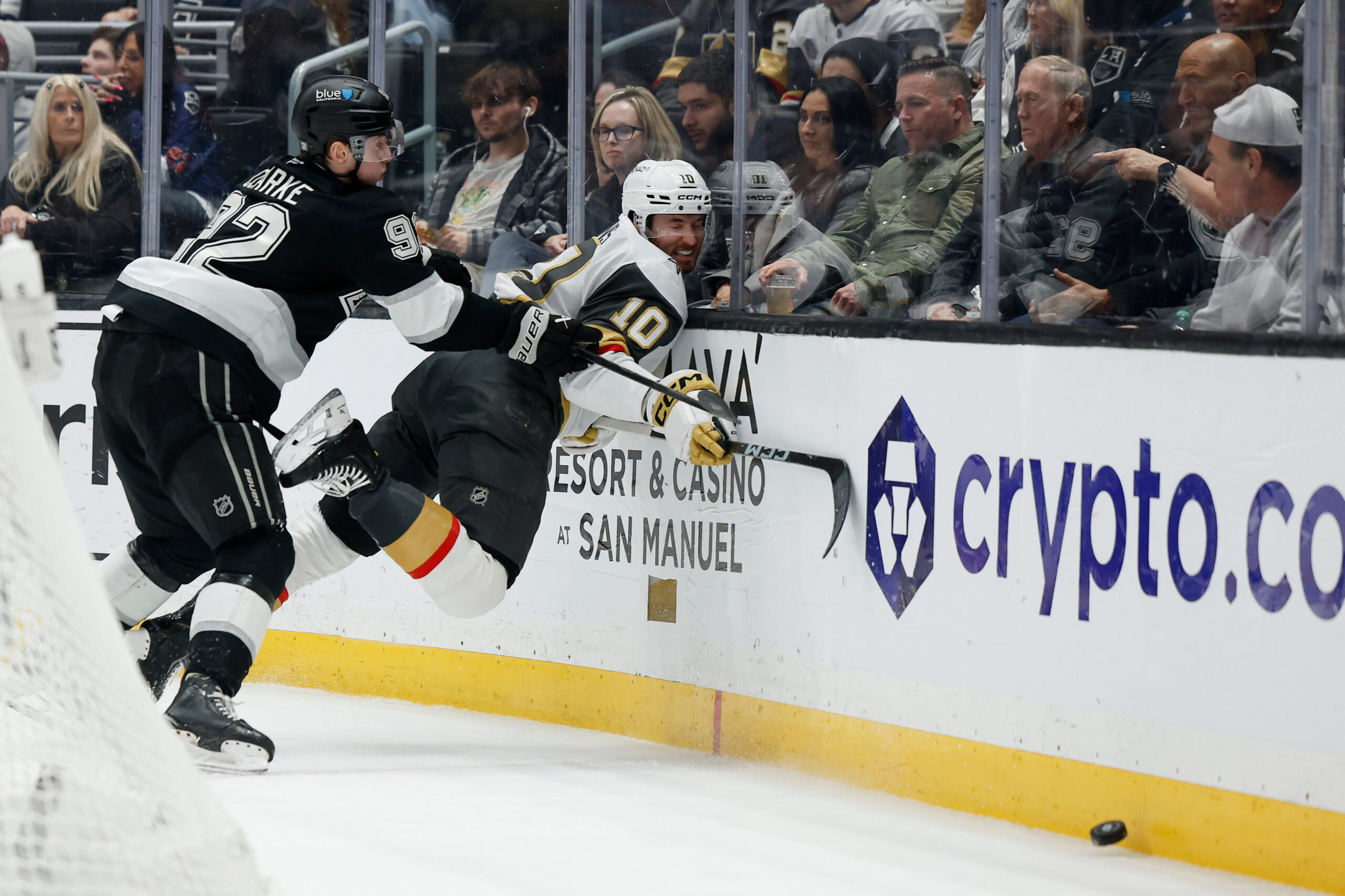 Kings defenseman Brandt Clarke, left, checks Vegas Golden Knights center...