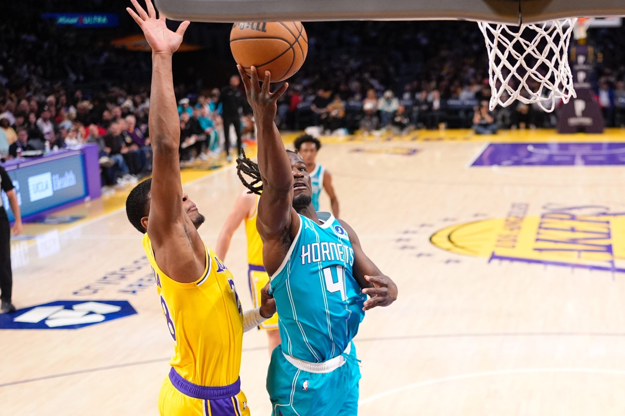 Charlotte Hornets guard Sion James, right, shoots as Lakers forward...