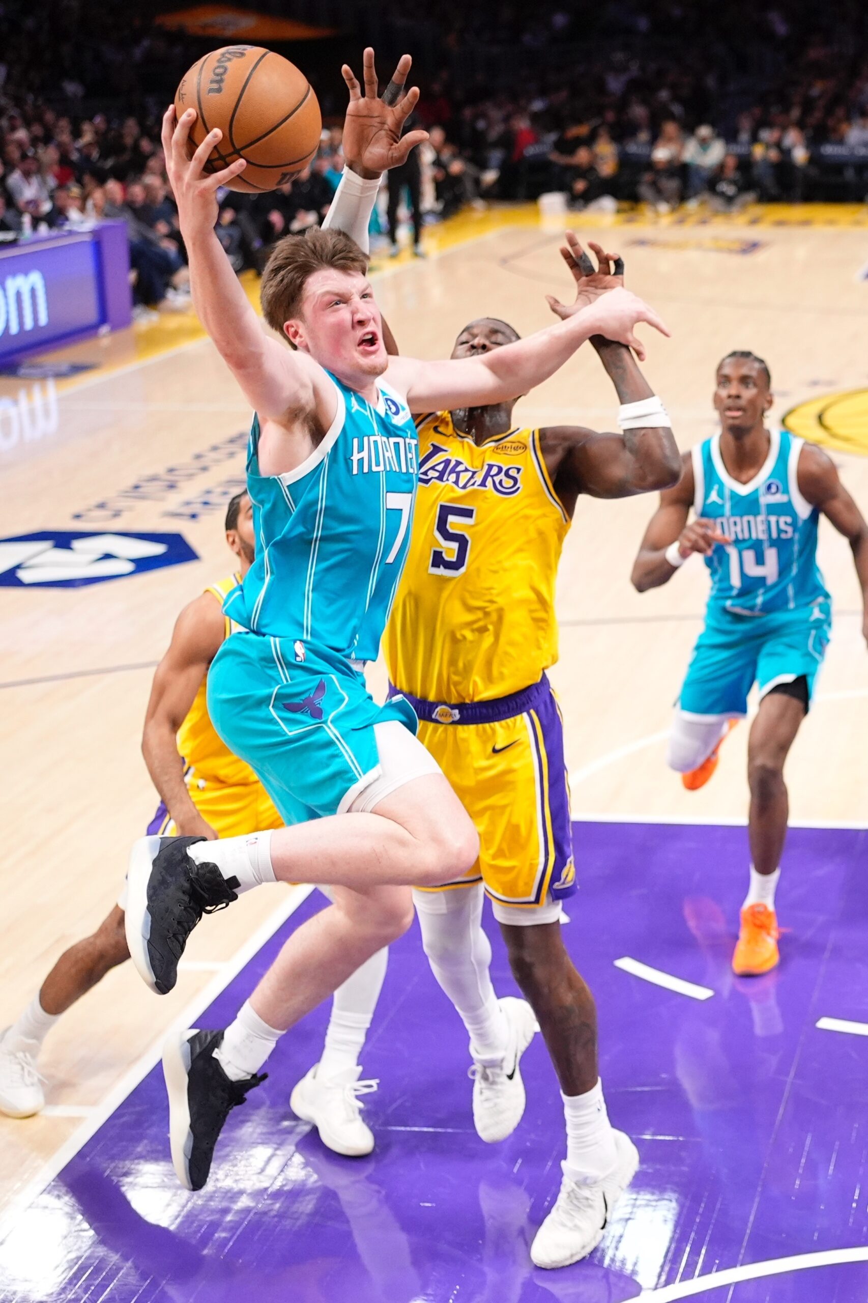 Charlotte Hornets guard Kon Knueppel, left, shoots as Lakers center...