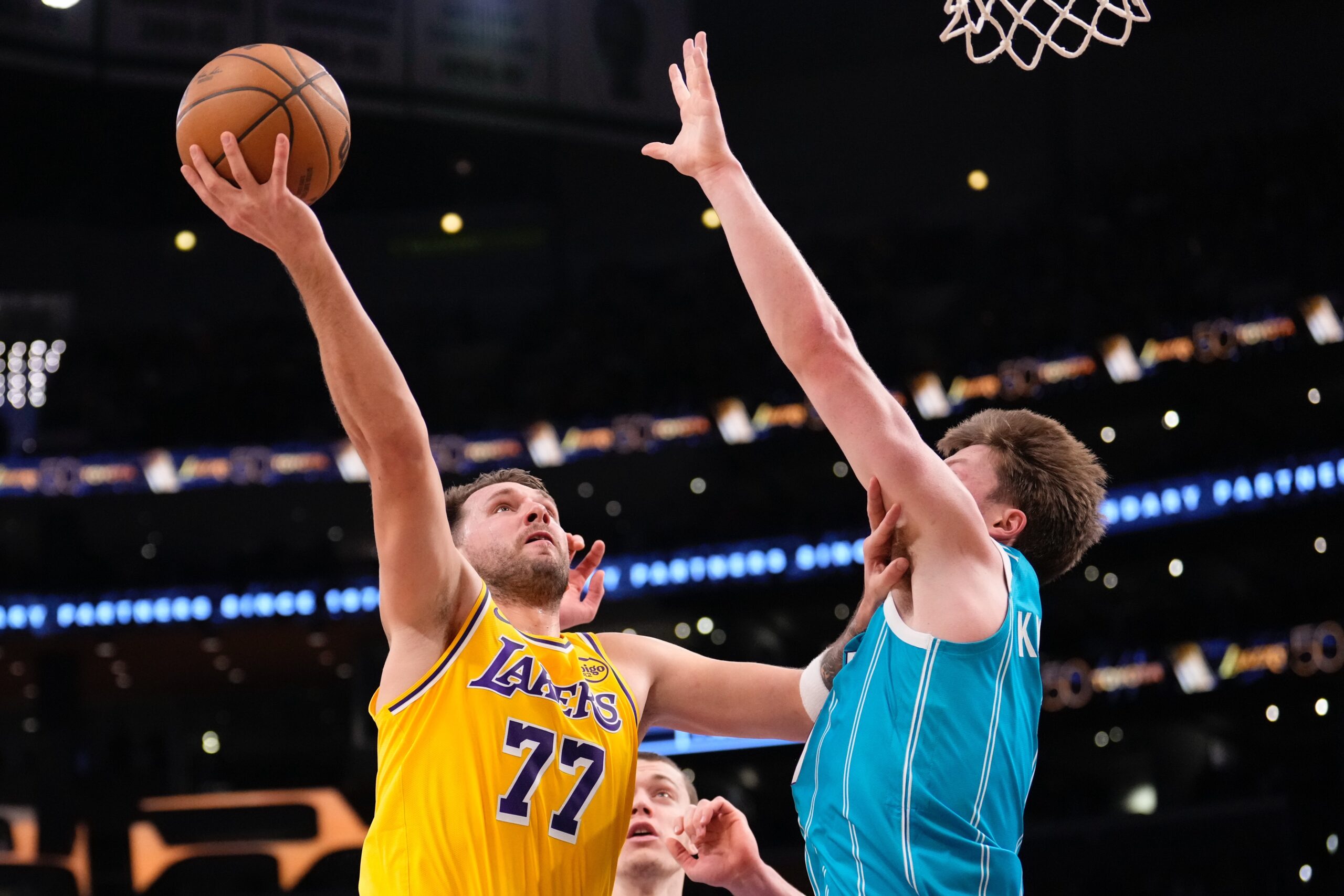Lakers guard Luka Doncic, left, shoots as Charlotte Hornets guard...