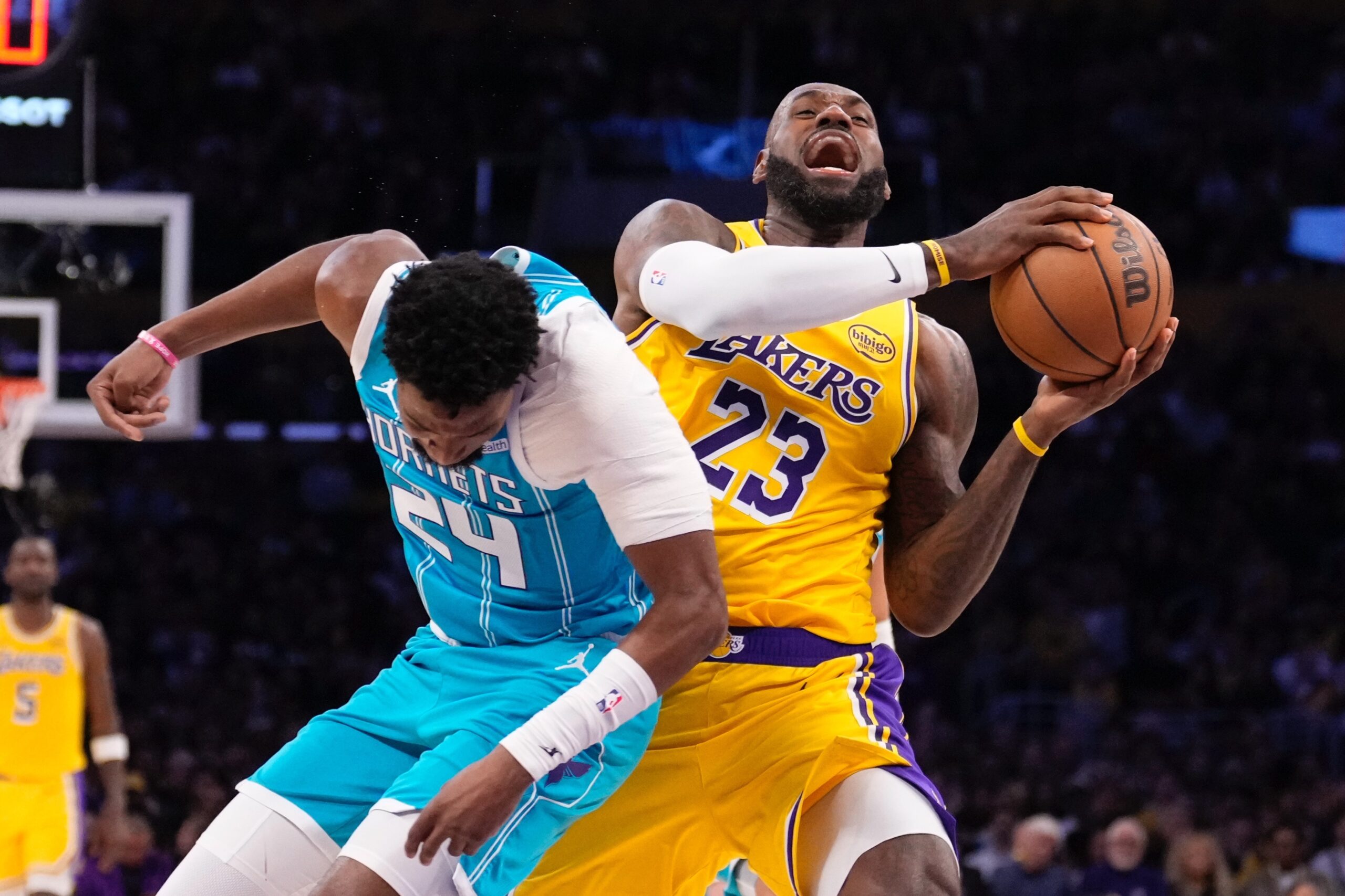 Lakers forward LeBron James, right, drives past Charlotte Hornets forward...
