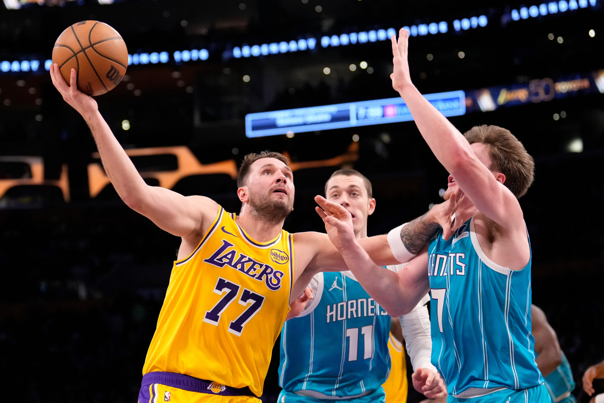 Lakers guard Luka Doncic, left, shoots as Charlotte Hornets center...