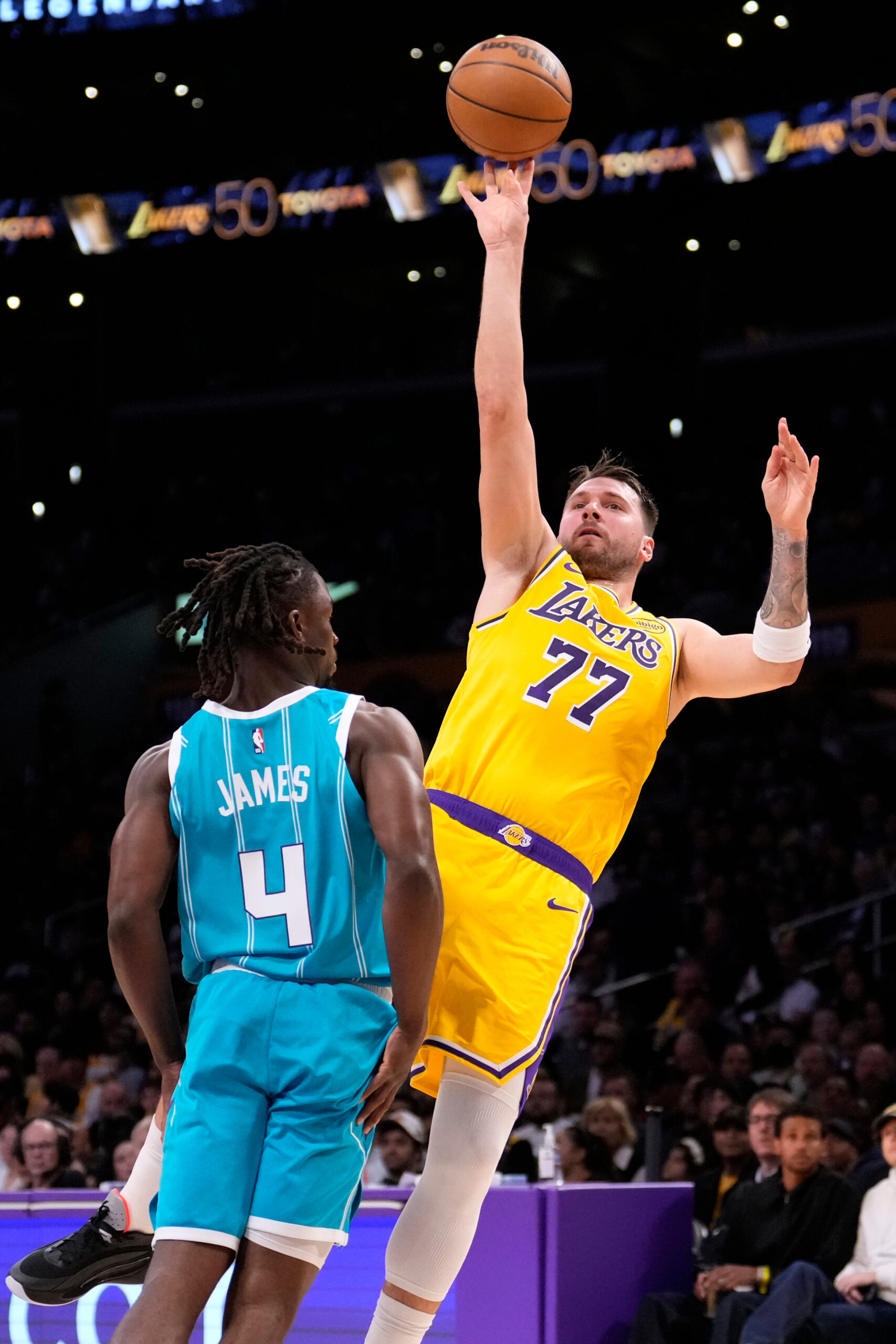 Lakers guard Luka Doncic, right, shoots as Charlotte Hornets guard...