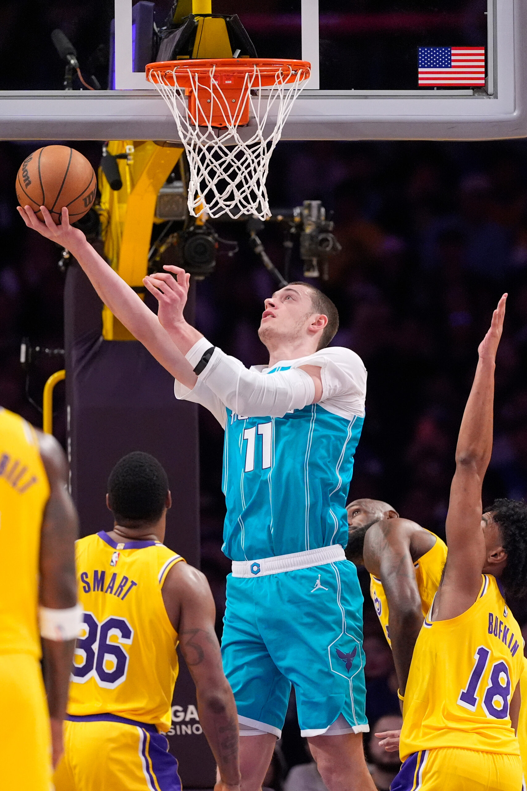 Charlotte Hornets center Ryan Kalkbrenner, second from left, shoots as...