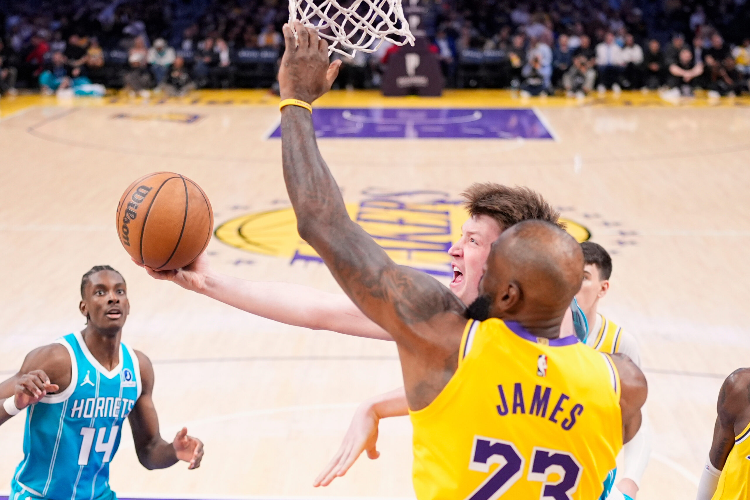 Charlotte Hornets guard Kon Knueppel, center, shoots as Lakers forward...