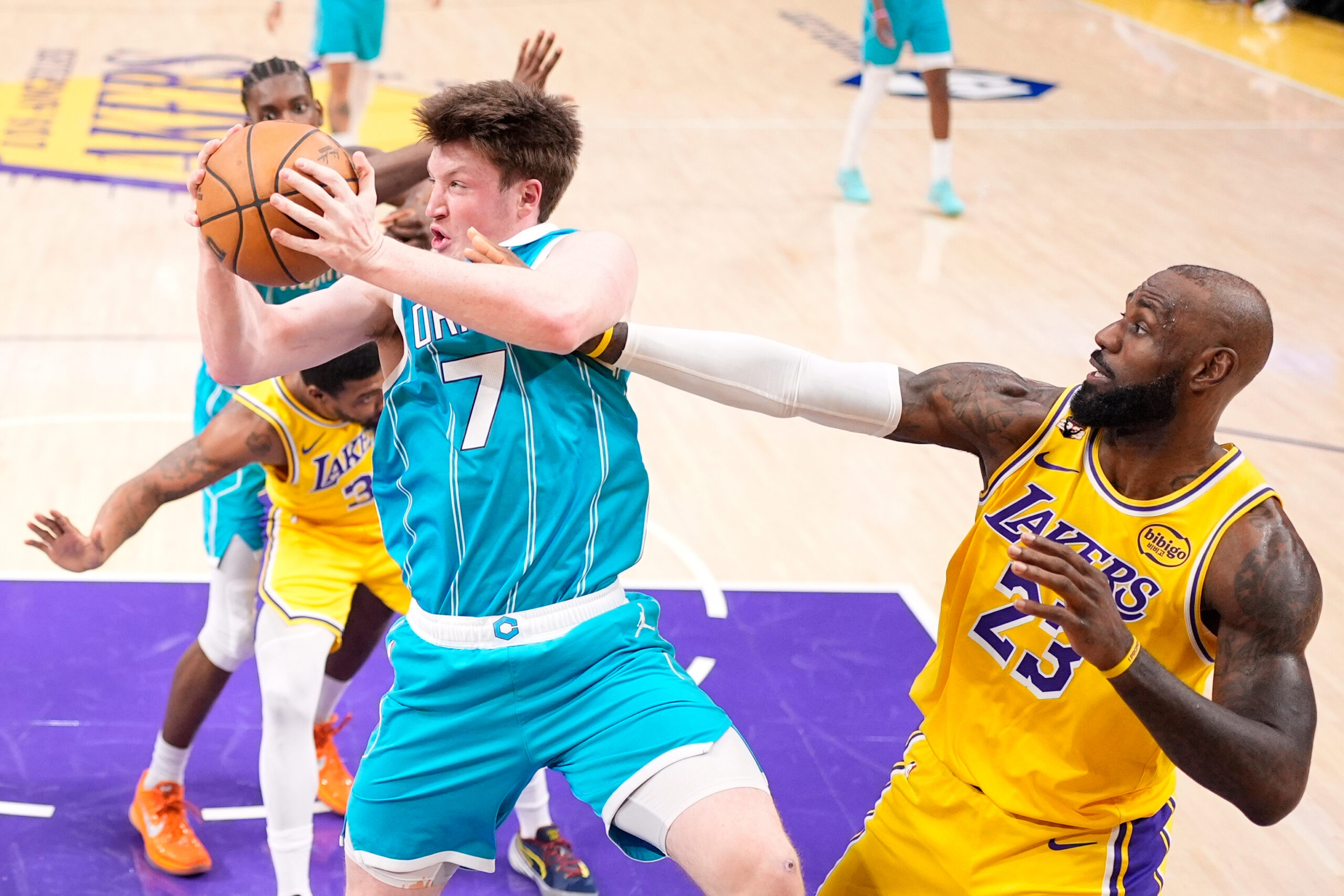 Charlotte Hornets guard Kon Knueppel, left, grabs a rebound away...