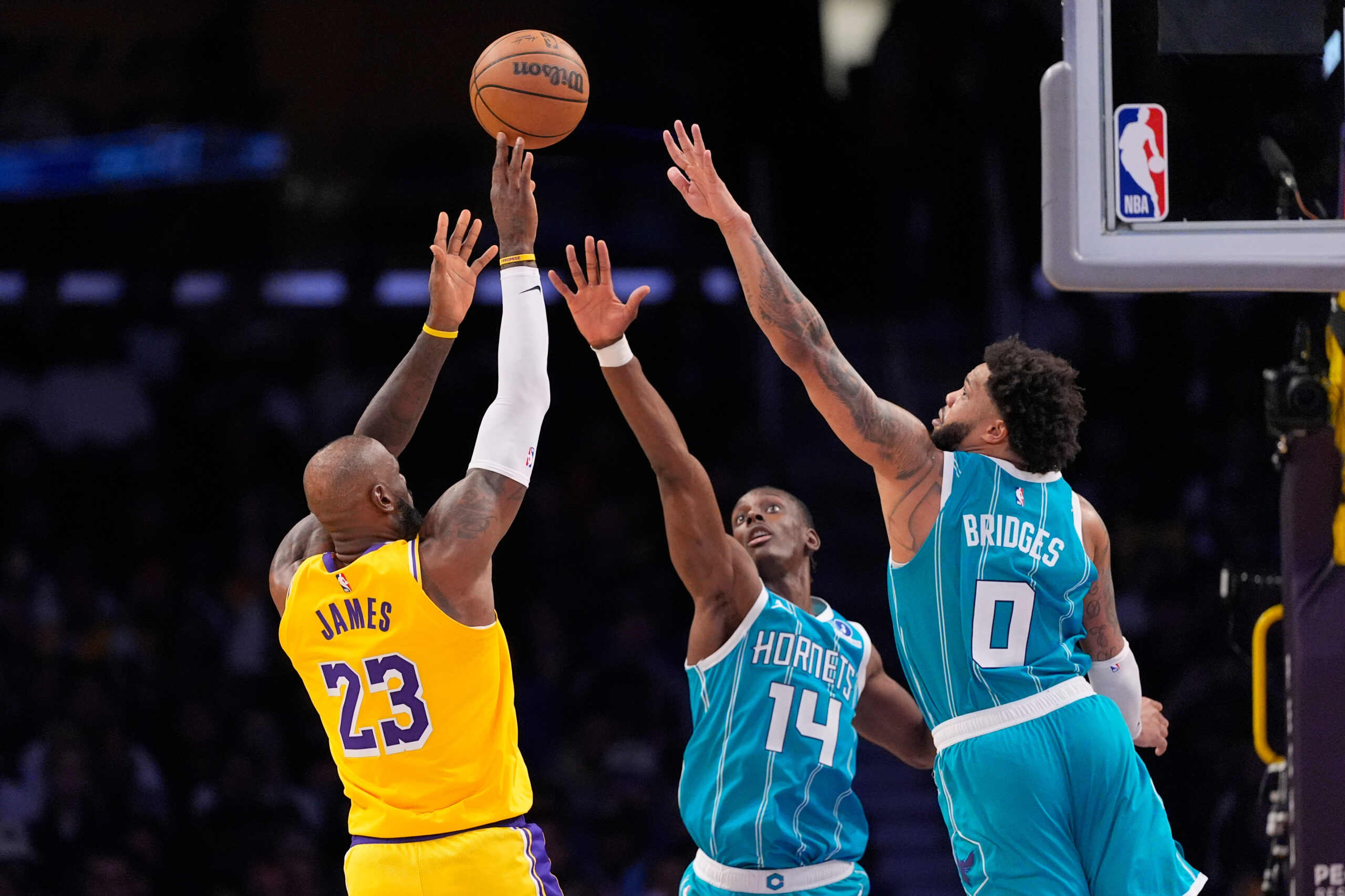 Lakers forward LeBron James left, shoots as Charlotte Hornets forward...