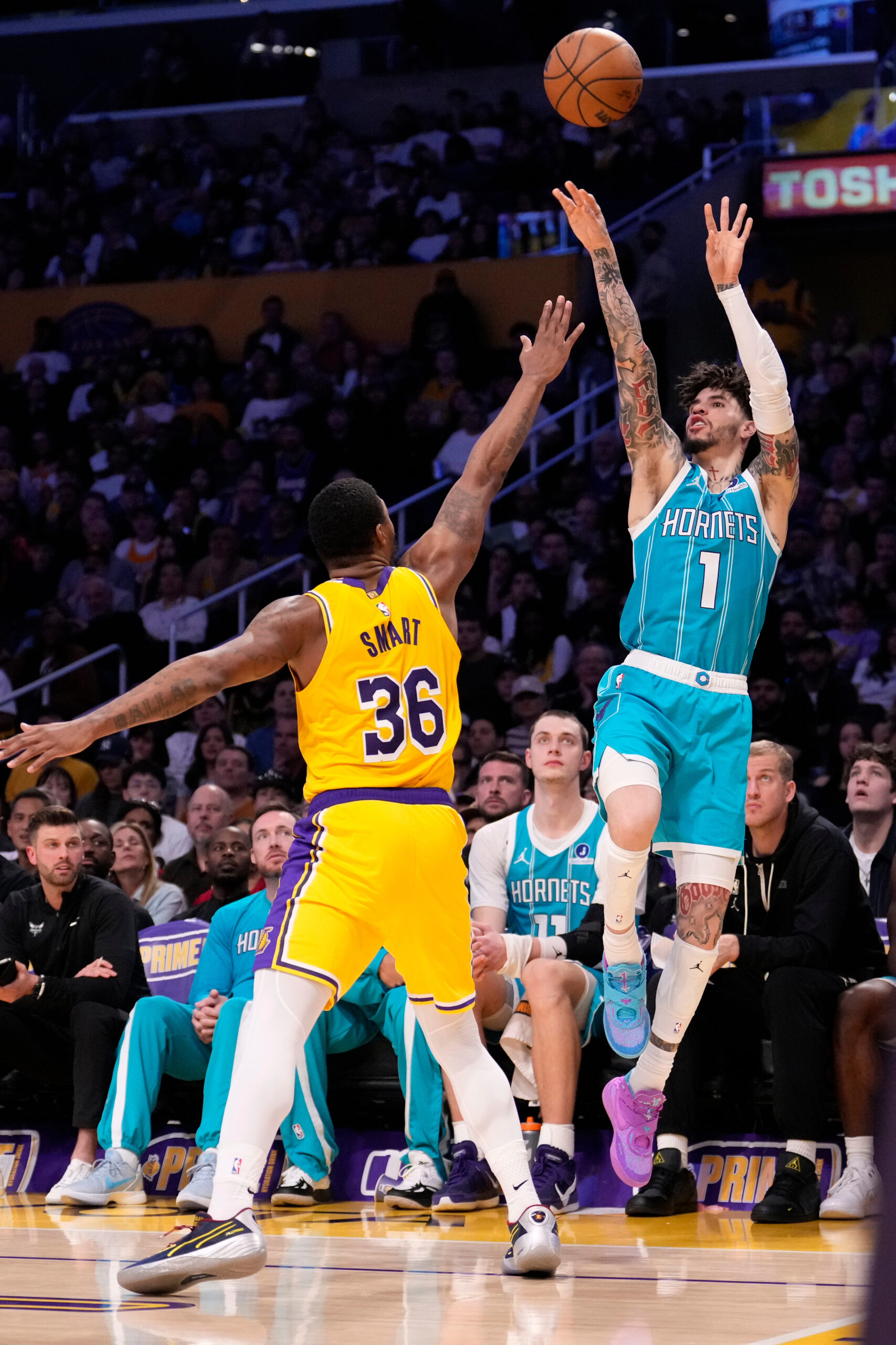 Charlotte Hornets guard LaMelo Ball, right, shoots as Lakers guard...