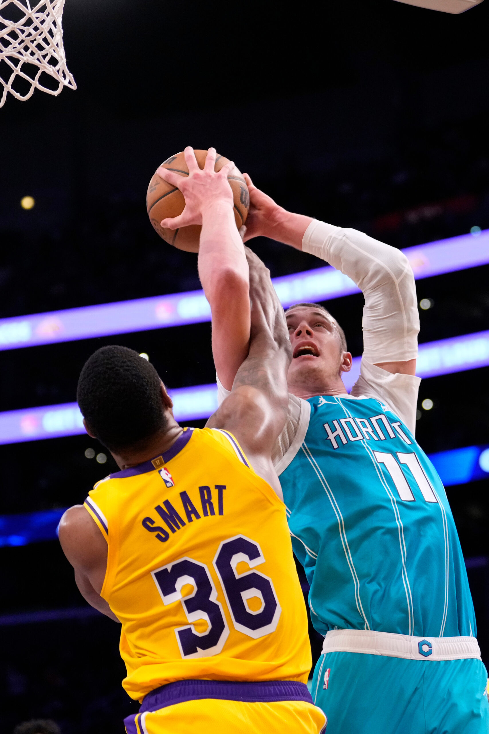 Charlotte Hornets center Ryan Kalkbrenner, right, shoots as Lakers guard...