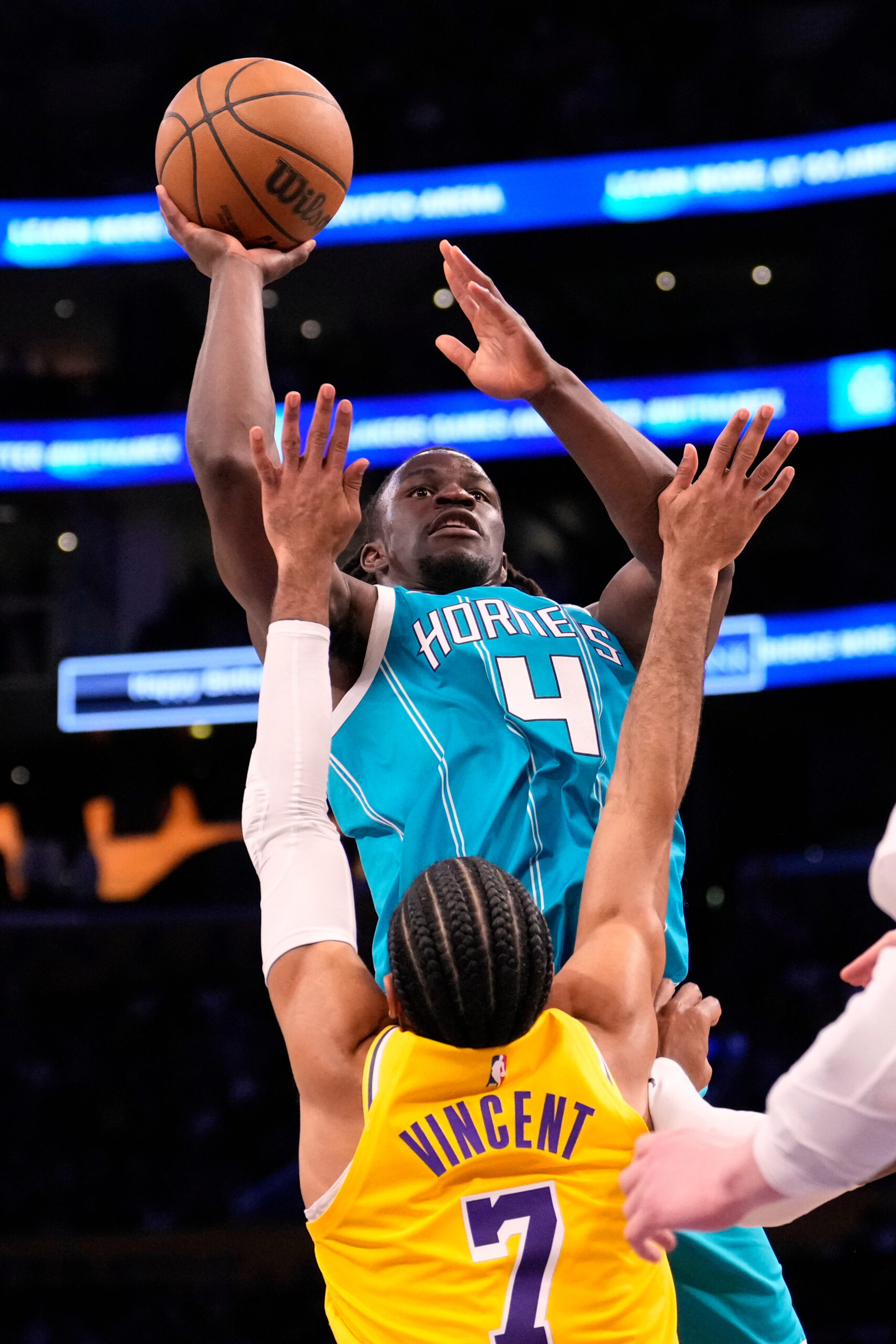 Charlotte Hornets guard Sion James, top, shoots as Lakers guard...