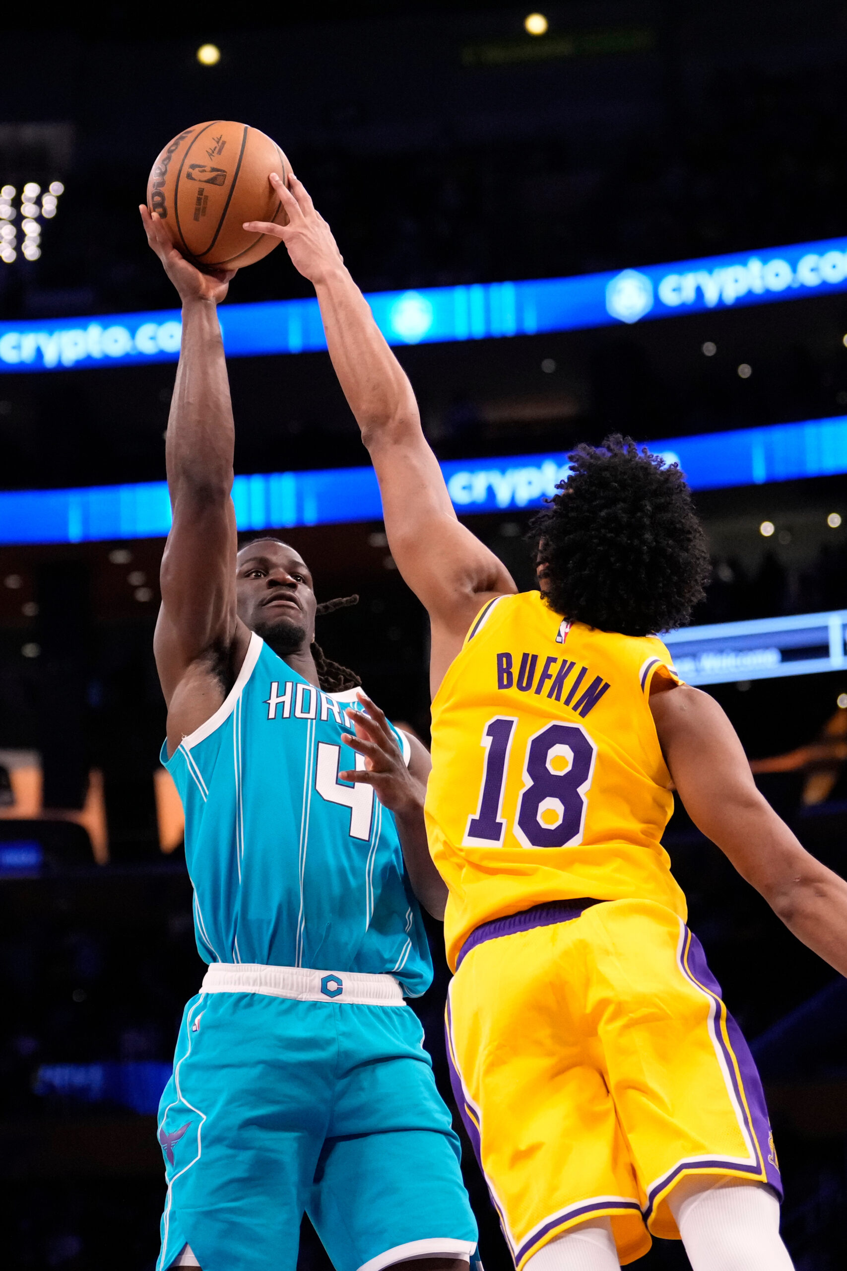 Charlotte Hornets guard Sion James, left, shoots as Lakers guard...