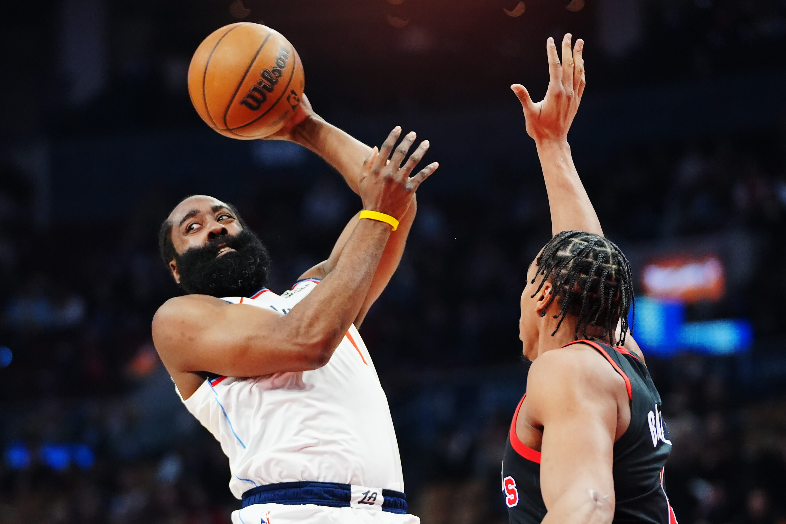 Clippers star James Harden, left, looks to pass the ball...