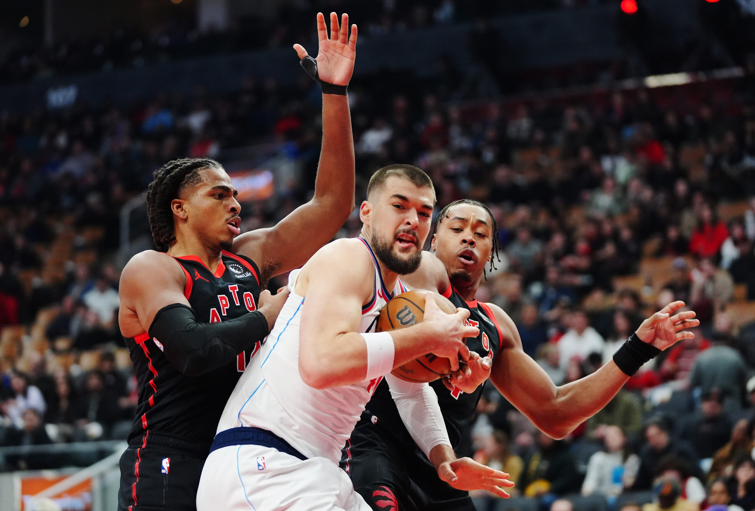 Clippers center Ivica Zubac, middle, battles for the ball with...