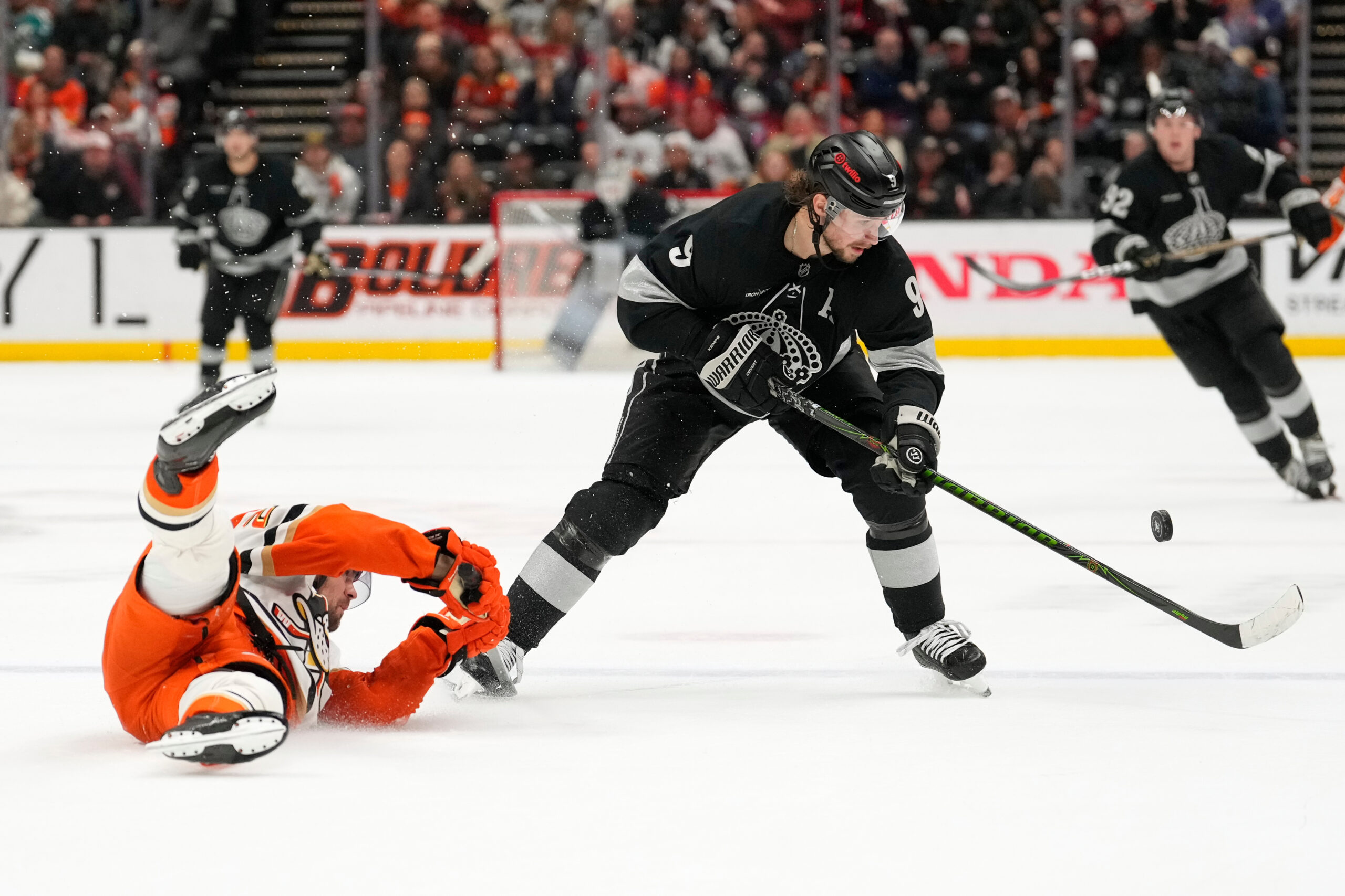Ducks center Ryan Poehling, left, falls as Kings right wing...