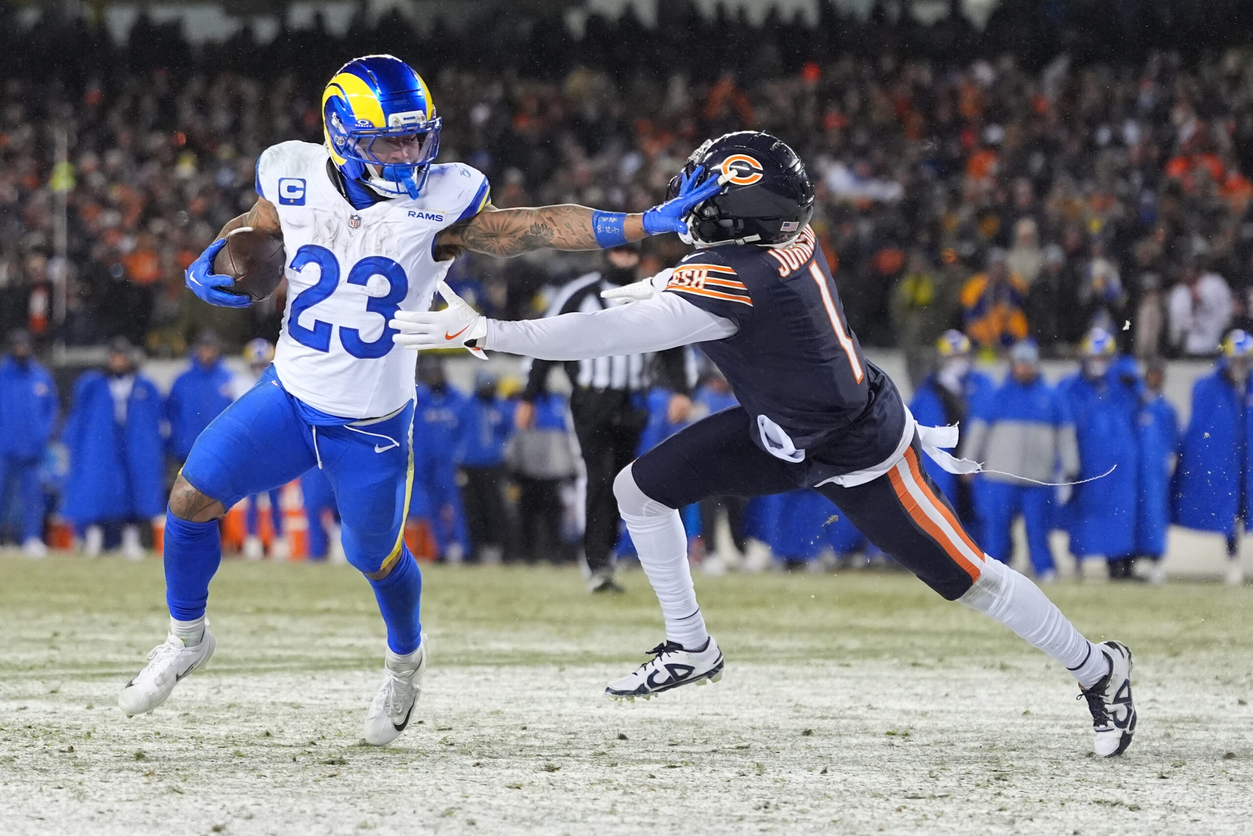 Rams running back Kyren Williams, left, stiff-arms Chicago Bears cornerback...