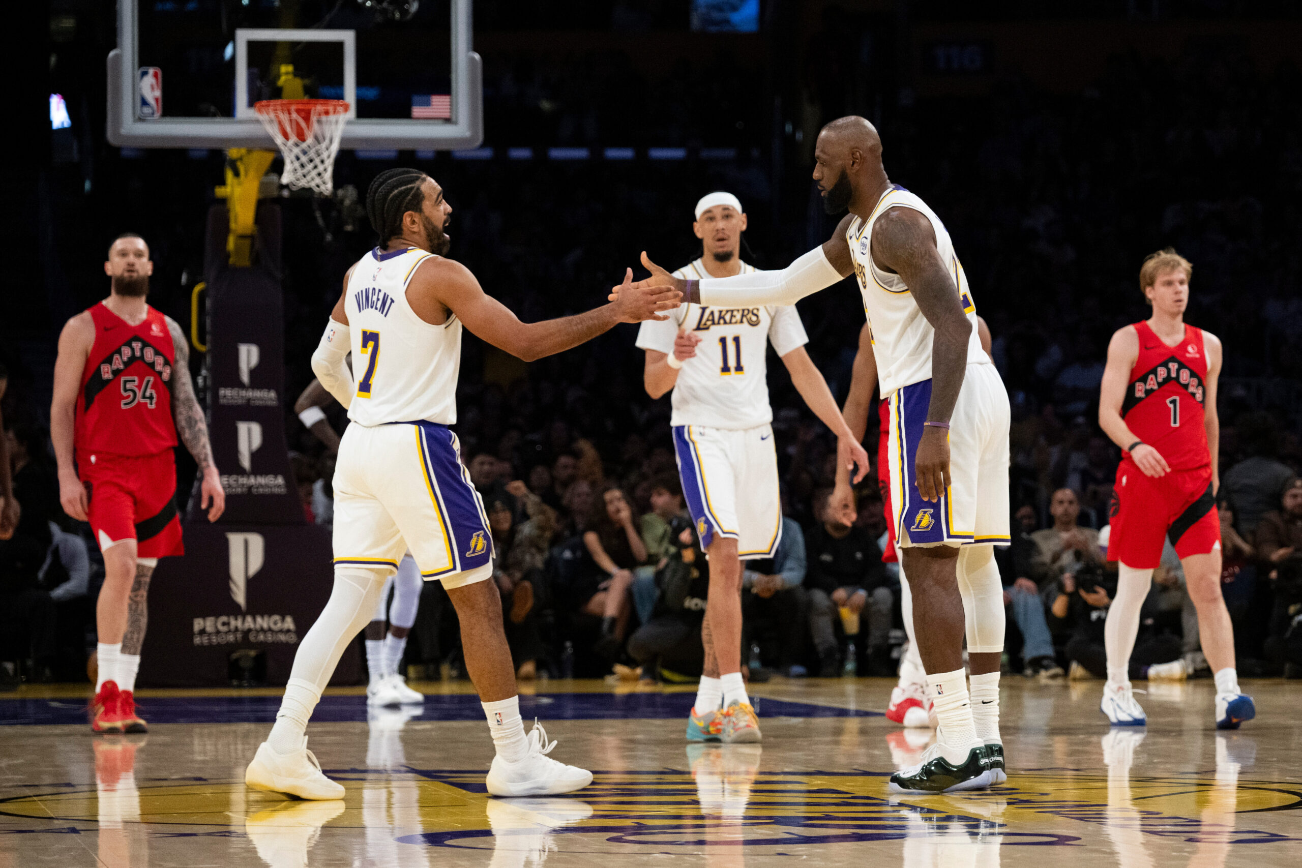 Lakers forward LeBron James, second right, celebrates his basket with...
