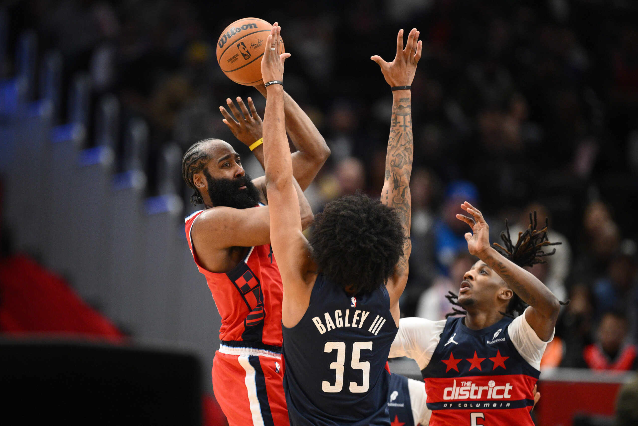 Clippers guard James Harden, left, looks to pass the ball...