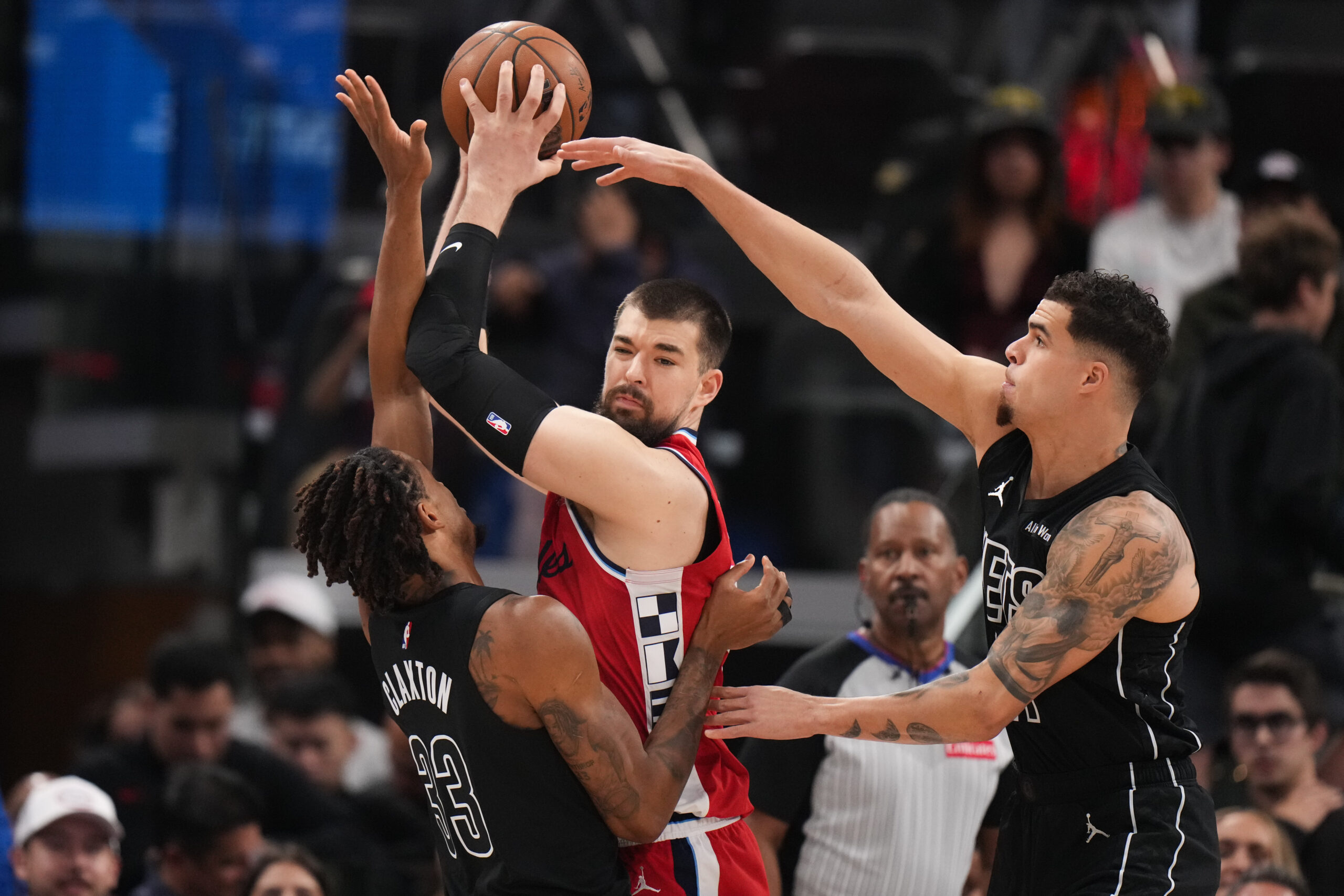 Clippers center Ivica Zubac, center, is defended by Brooklyn Nets...