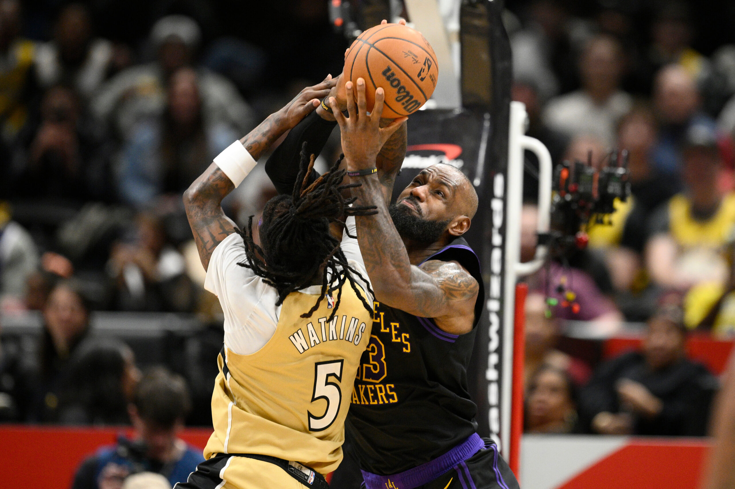 Lakers forward LeBron James, right, battles for the ball against...