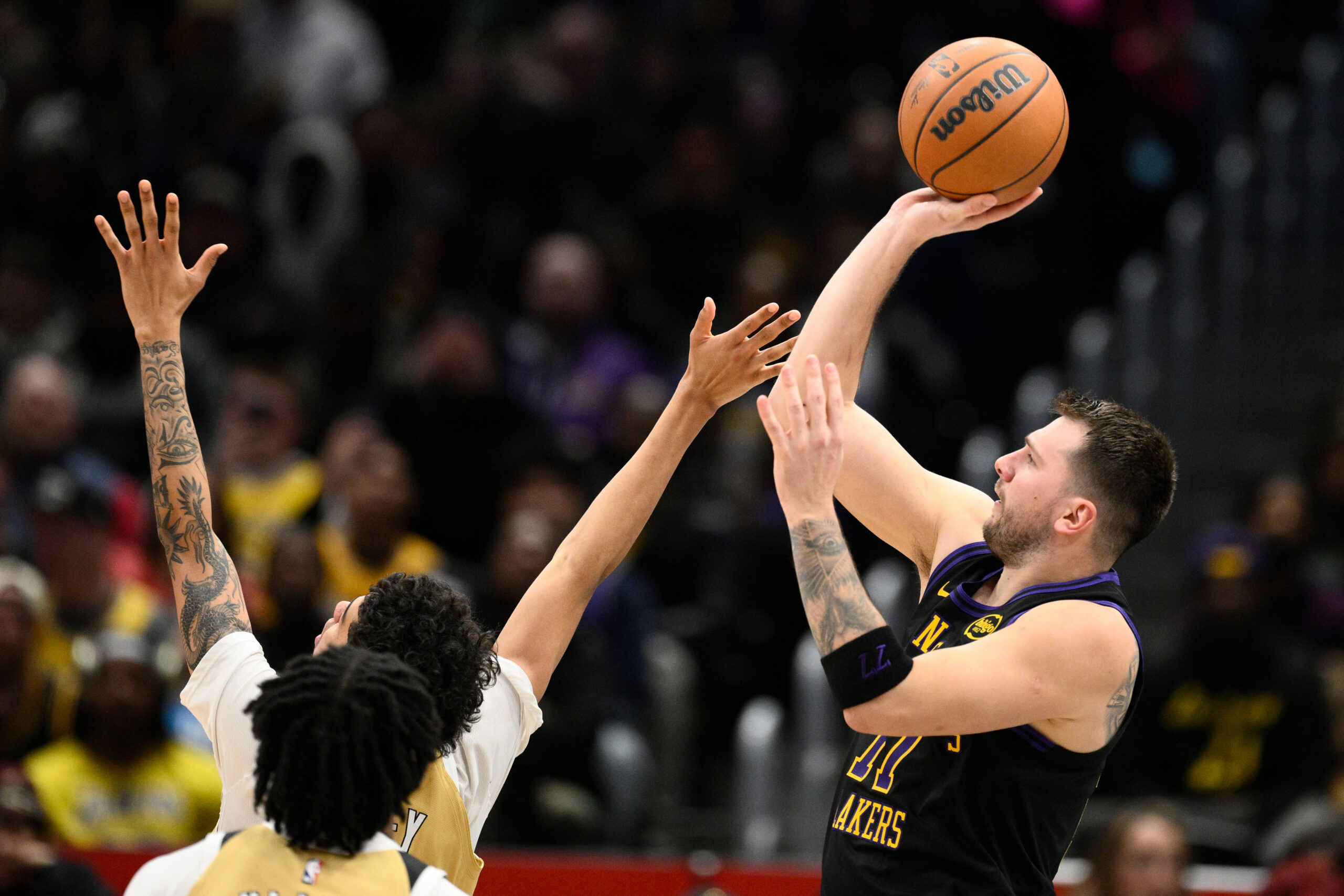 Lakers star Luka Doncic, right, looks to shoot during the...