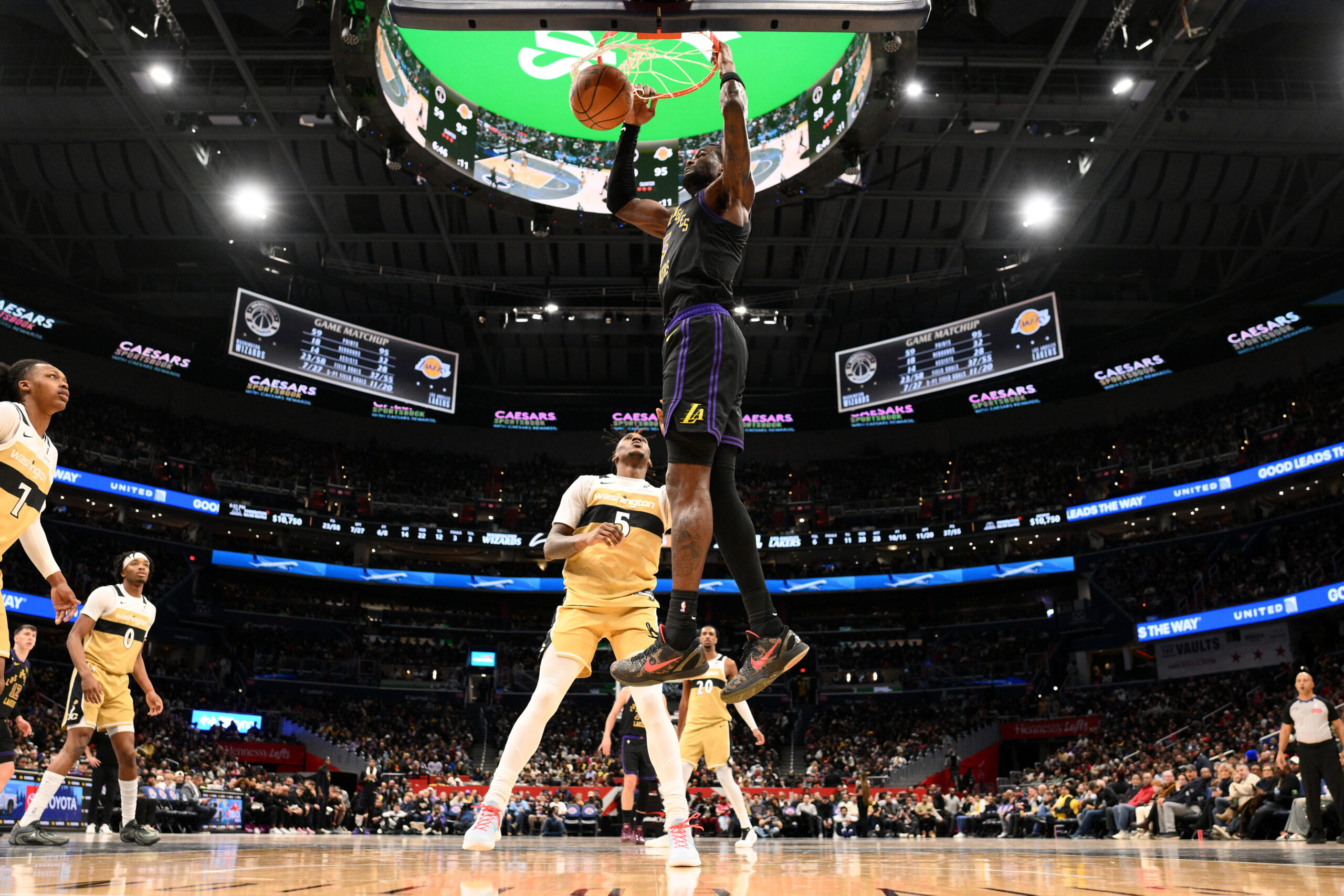Lakers center Deandre Ayton, top center, dunks over Washington Wizards...