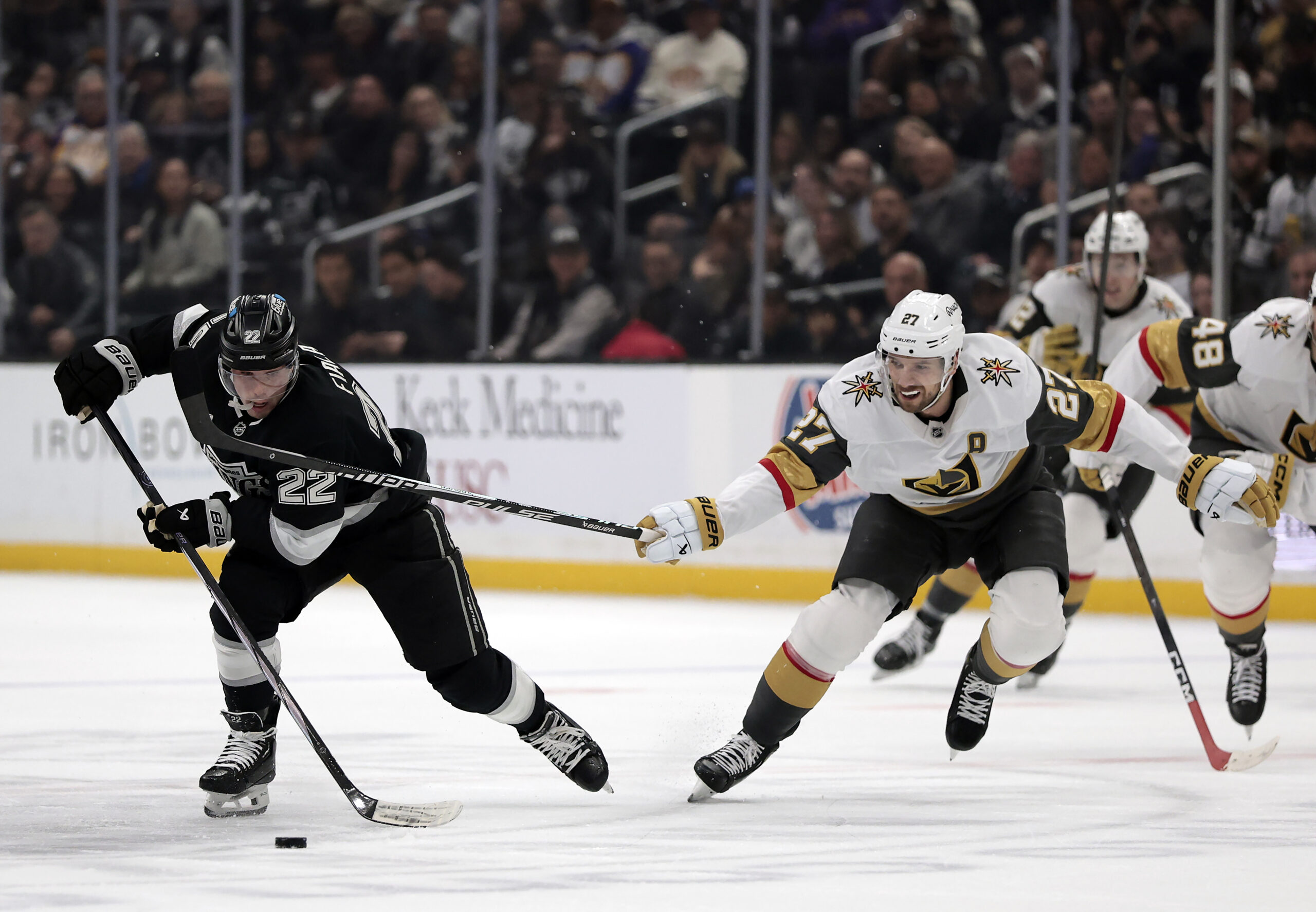 The Kings’ Kevin Fiala, left, skates with the puck as...