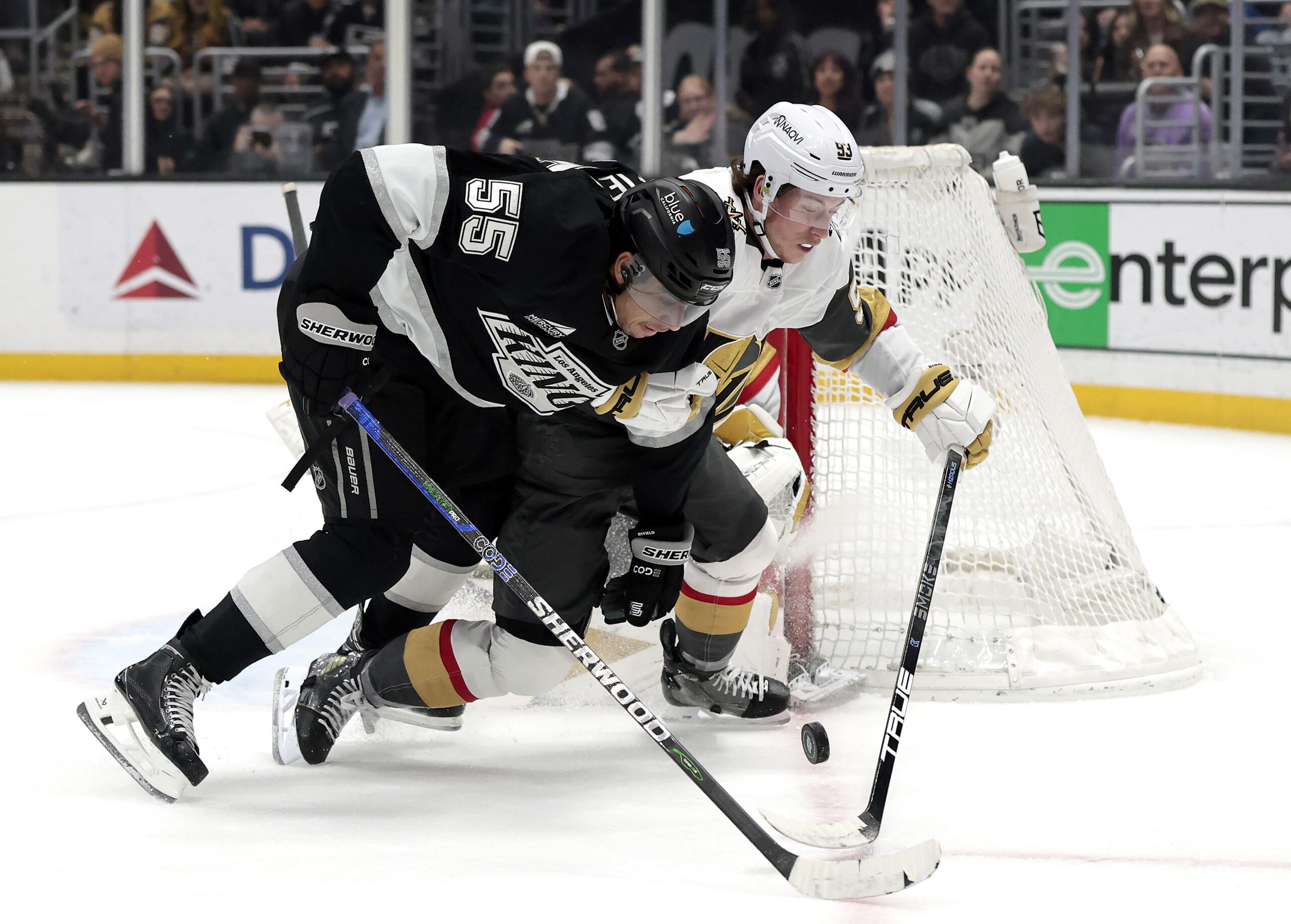 The Kings’ Quinton Byfield, front, skates for the puck against...