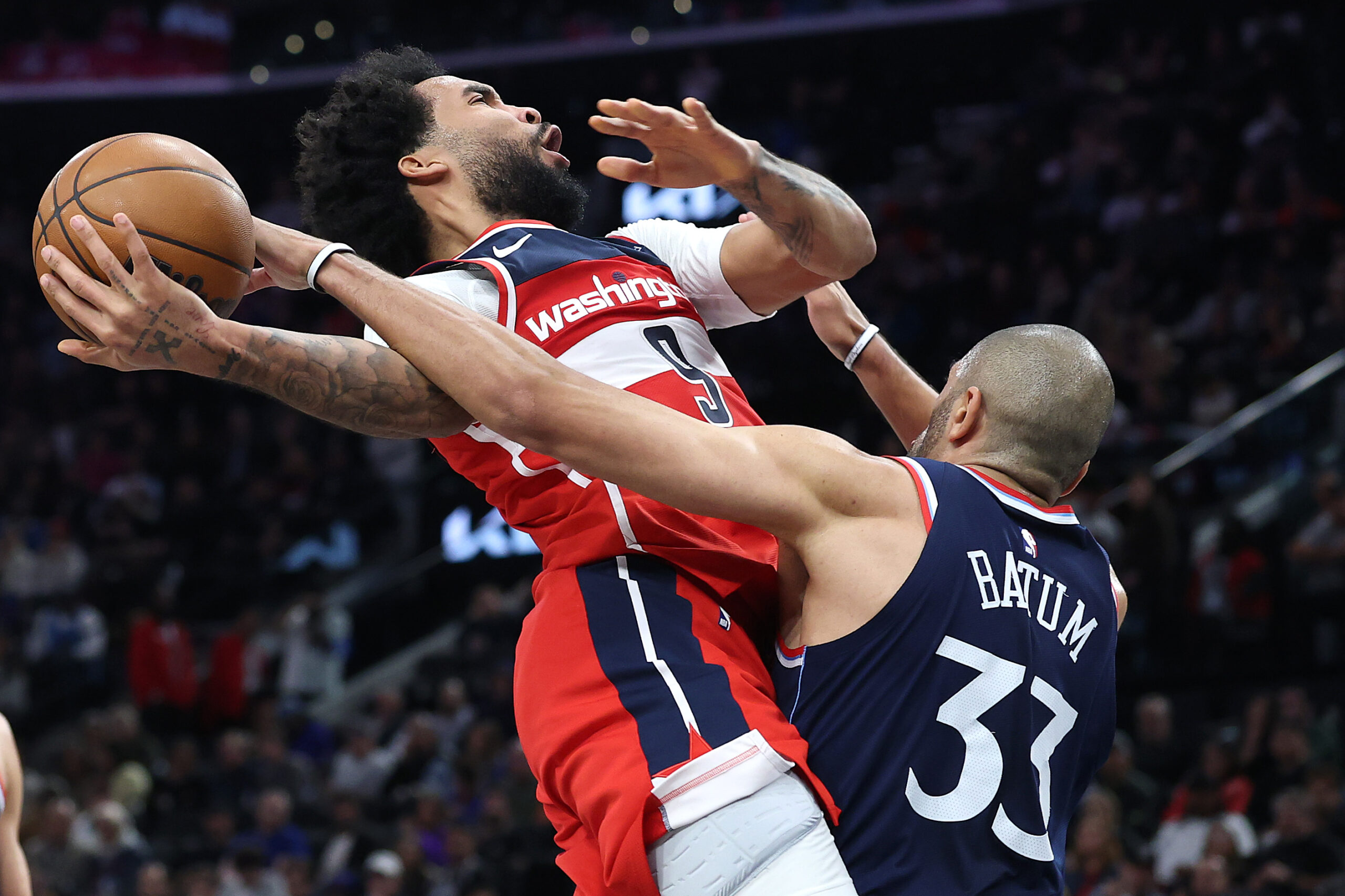 Clippers forward Nicolas Batum, right, fouls the Washington Wizards’ Justin...