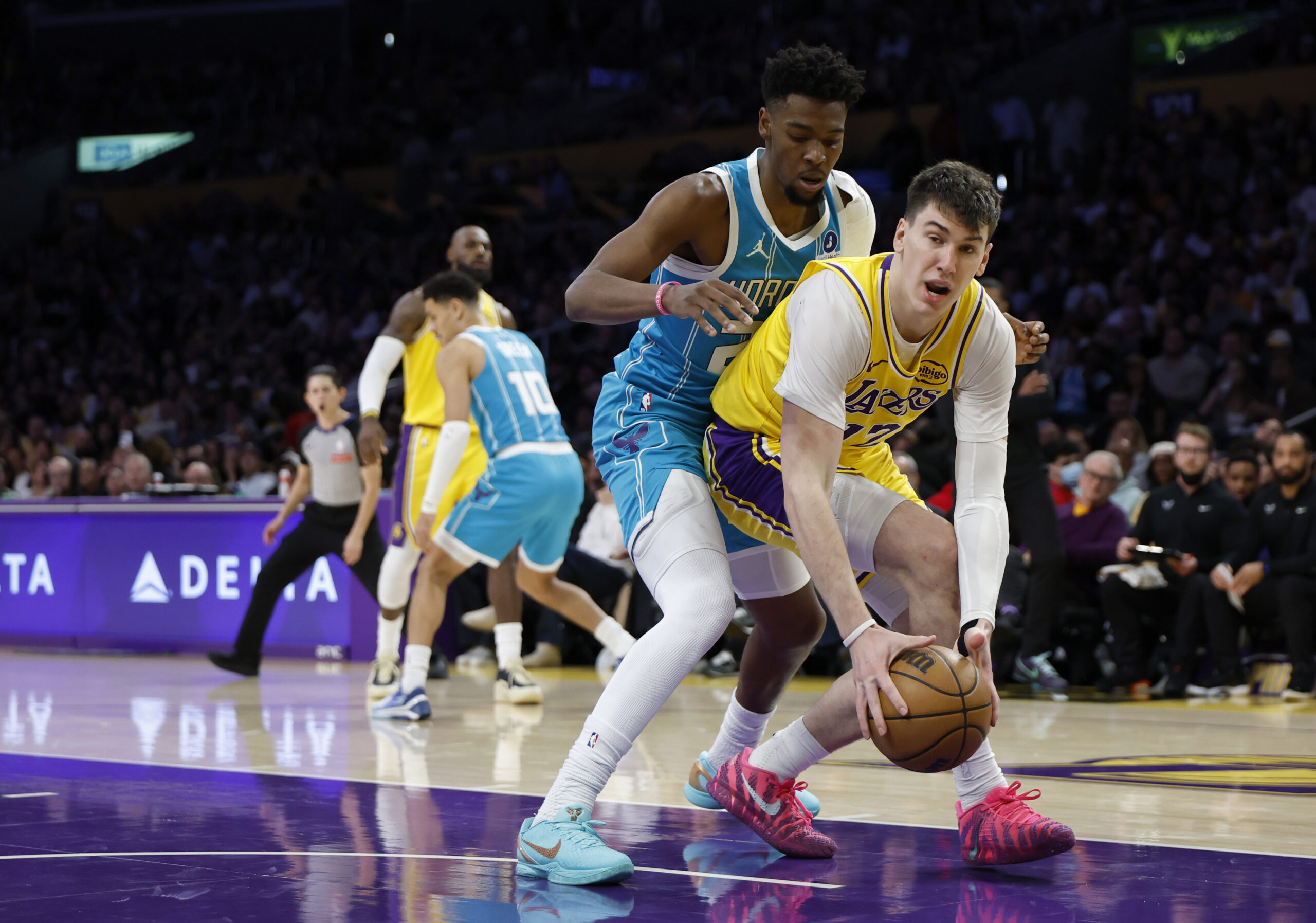 Lakers forward Jake LaRavia controls a rebound in front of...