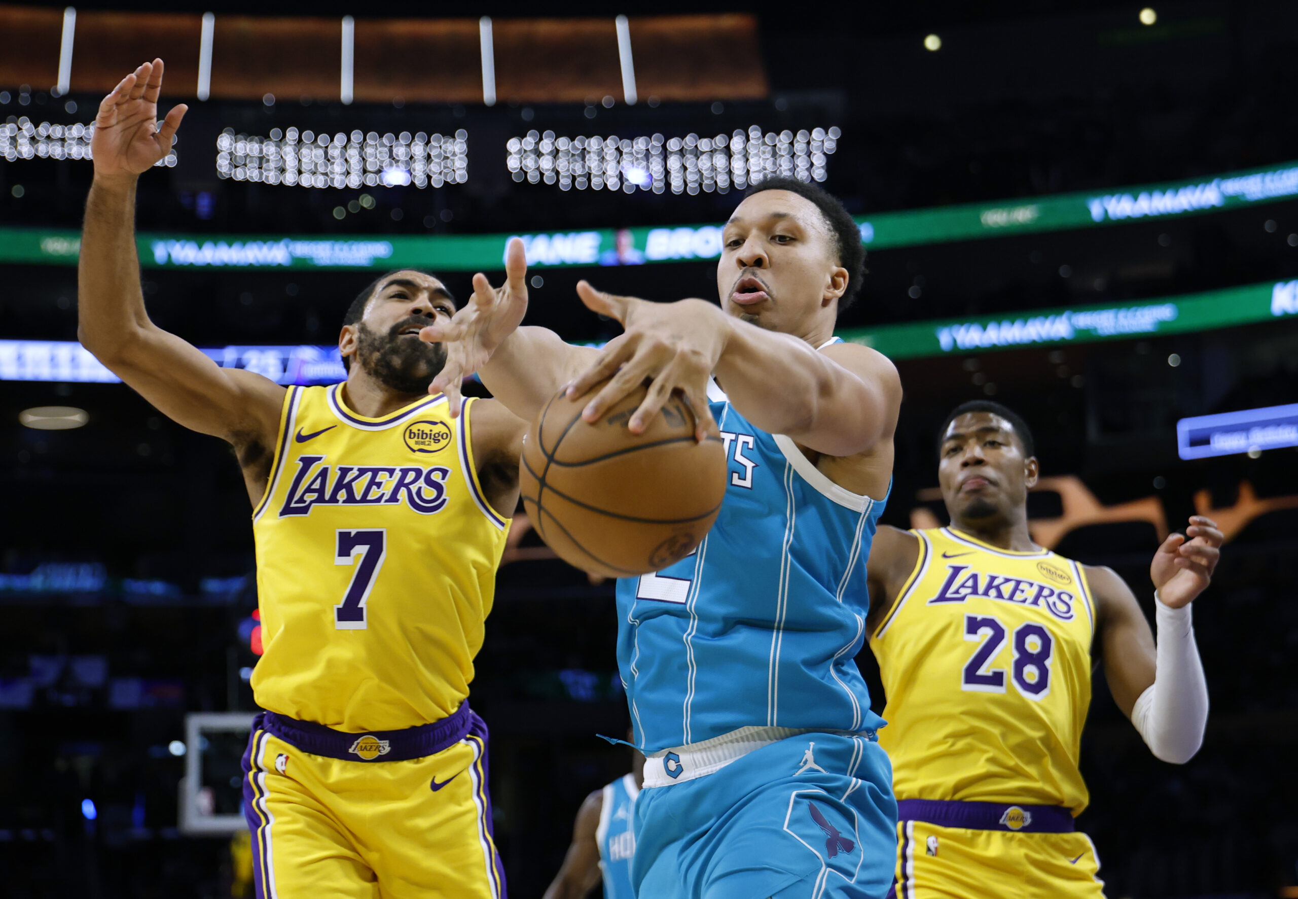 Charlotte Hornets rookie Kon Knueppel grabs a rebound in front...