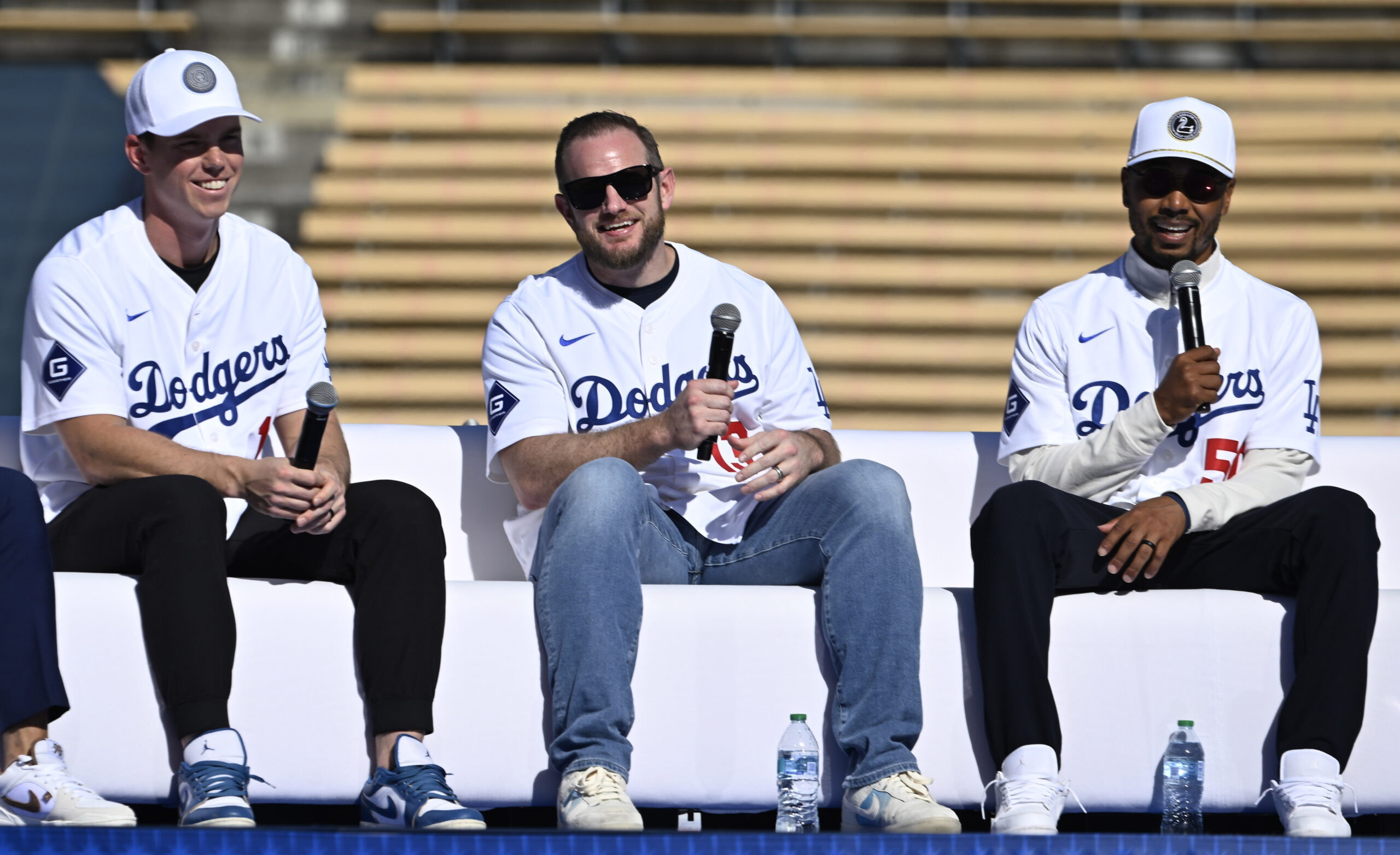 Will Smith, left, along with Max Muncy, center, listen as...