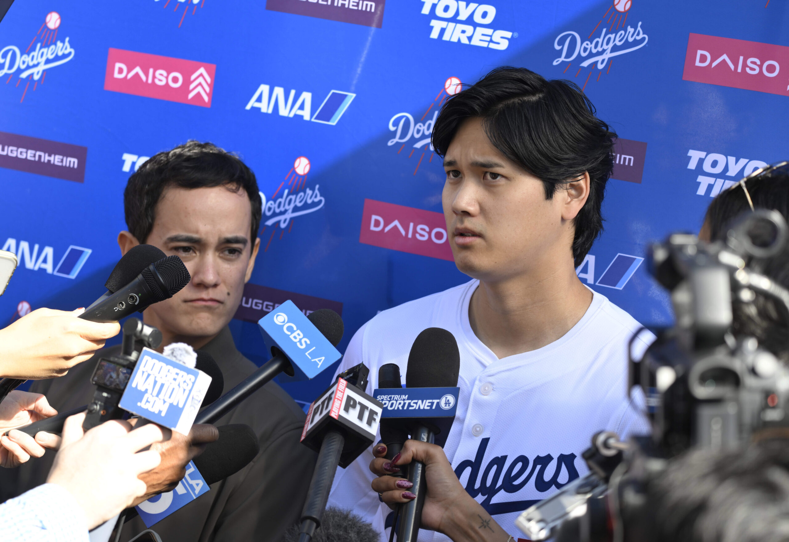 Dodgers star Shohei Ohtani, right, with the help of interpreter...