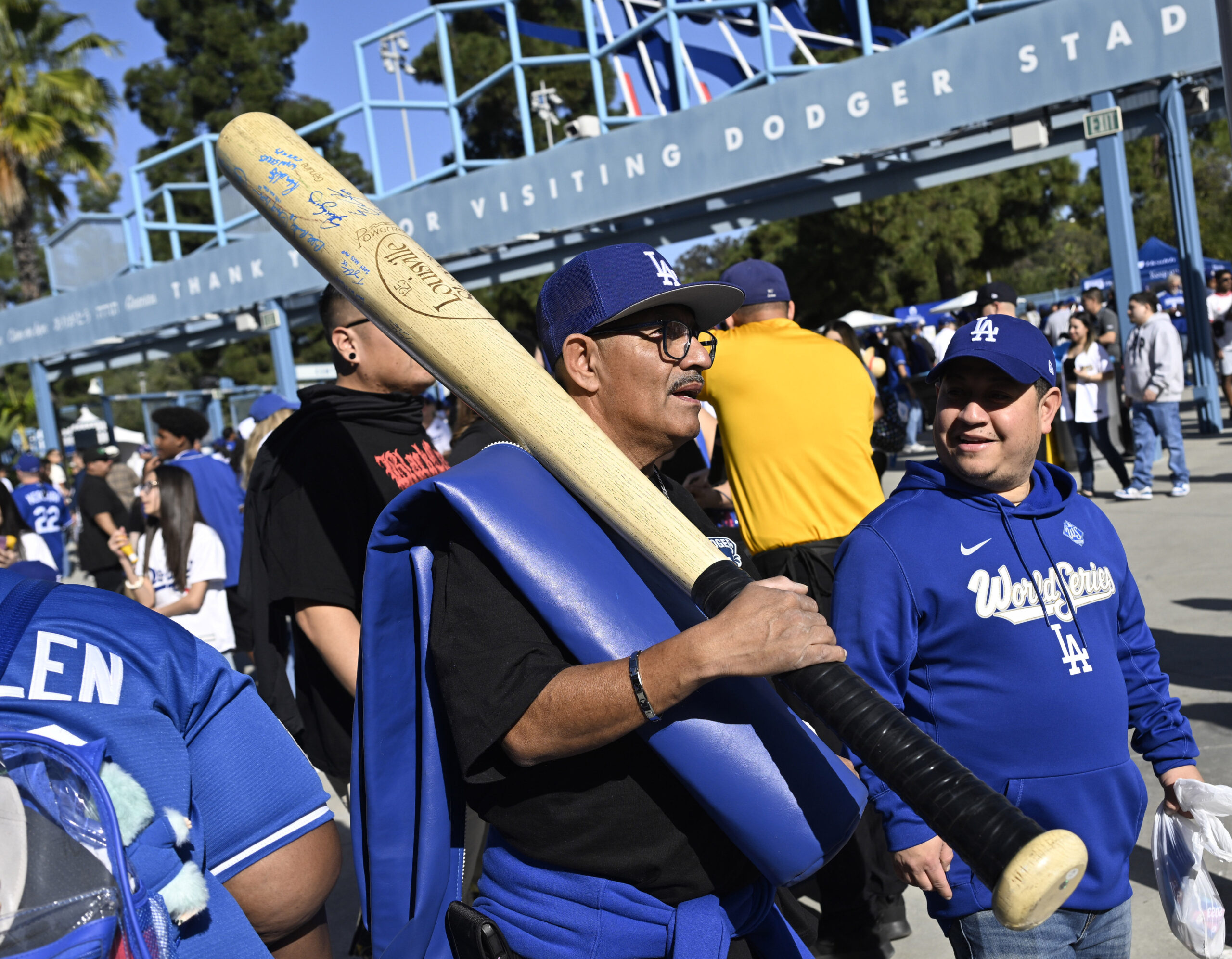 A Dodger fan with a giant bat makes his way...