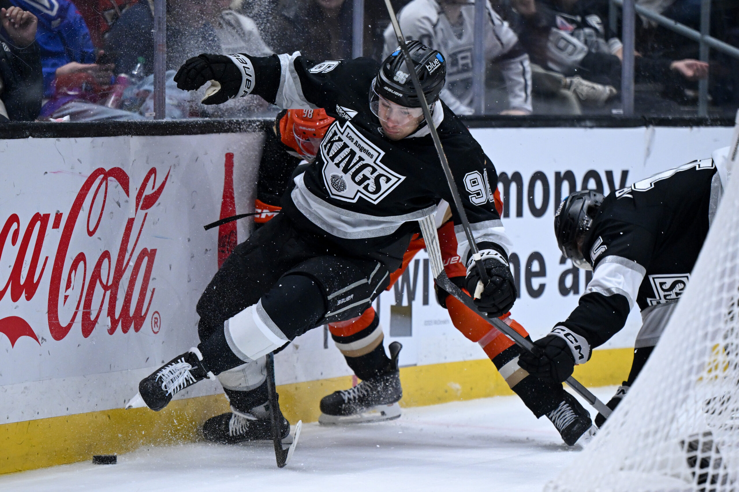 The Kings’ Andrei Kuzmenko (96) is tripped up behind the...