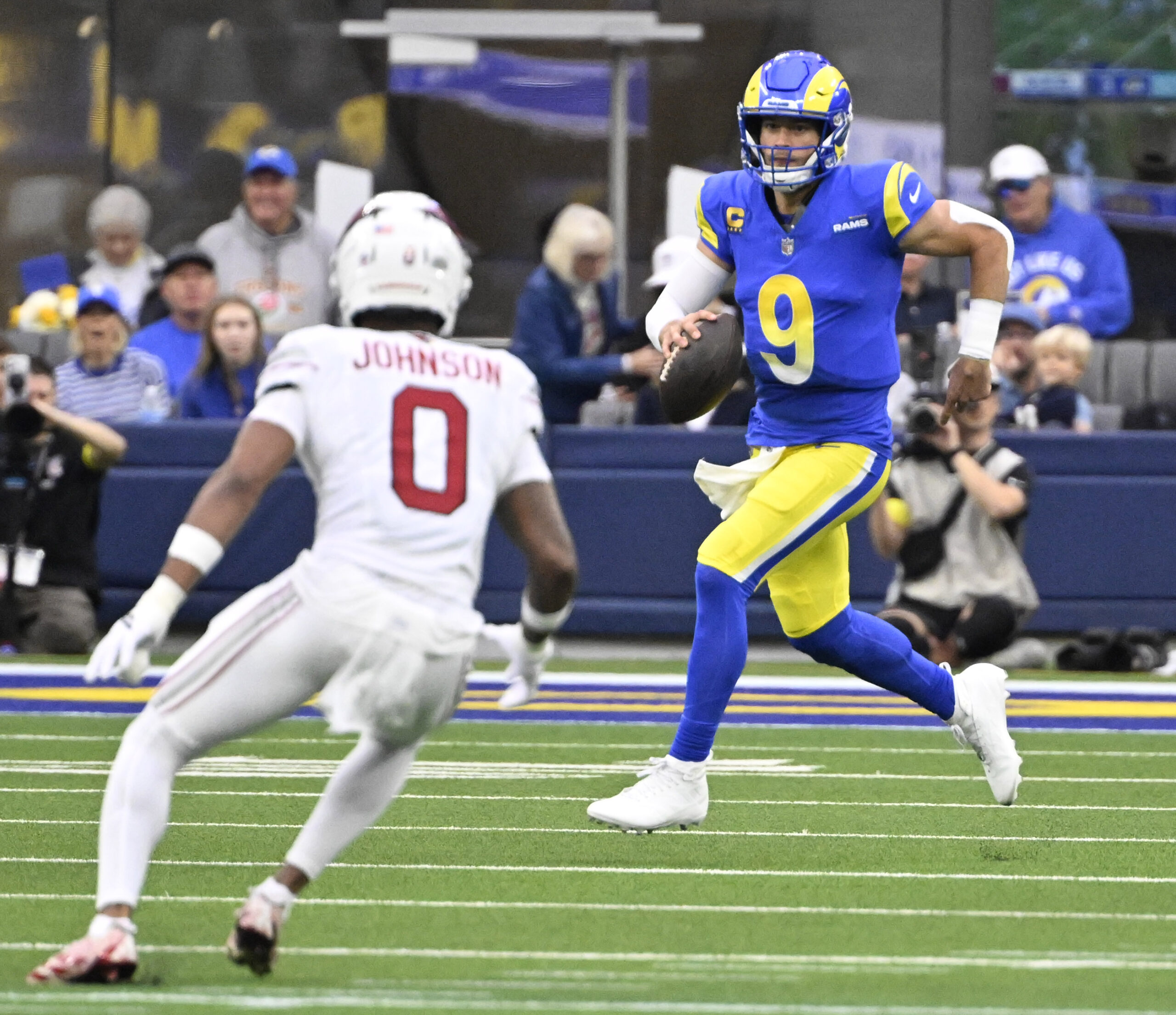Quarterback Matthew Stafford #9 of the Rams scrambles against Will...