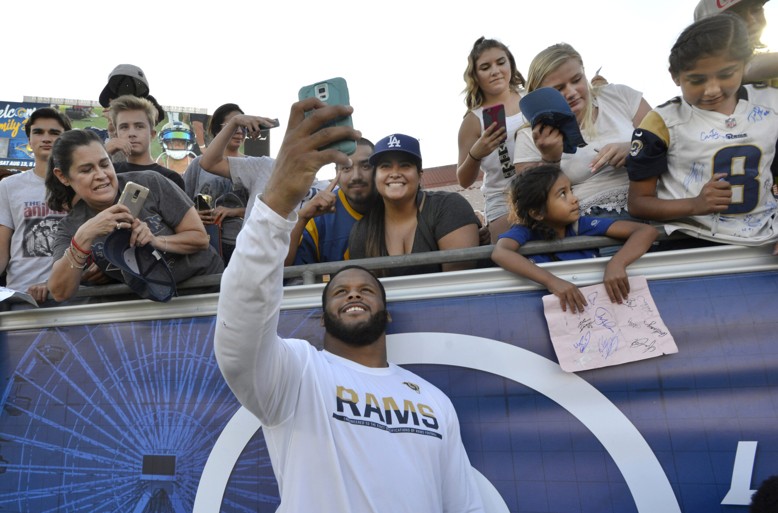 The Rams’ Aaron Donald takes a photo with fans after...
