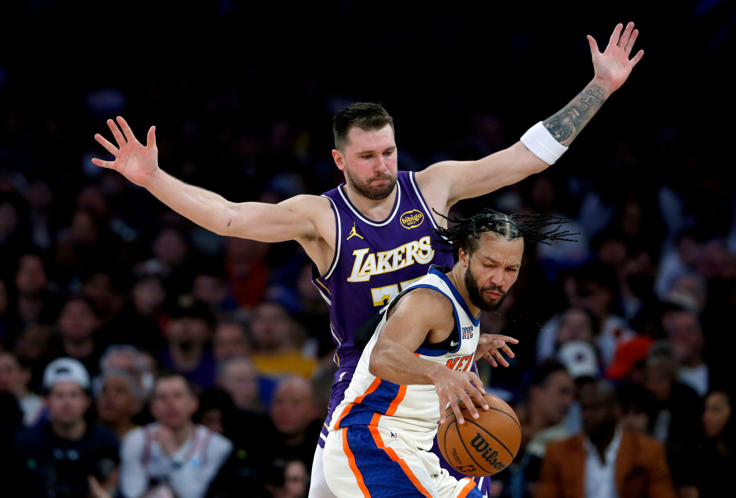 Lakers guard Luka Doncic, top, defends against New York Knicks...