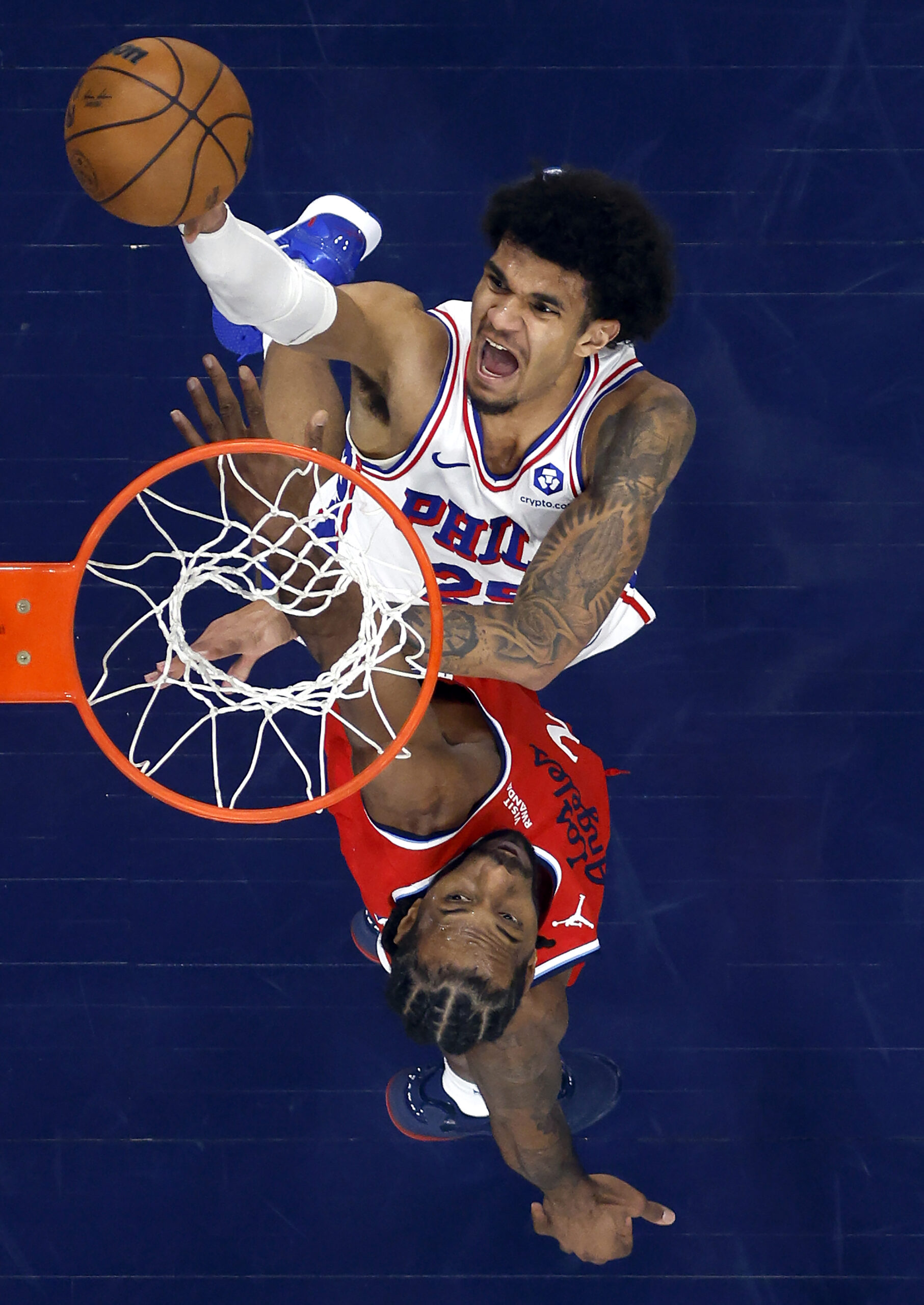 The Philadelphia 76ers’ Dominick Barlow, top, takes a shot as...