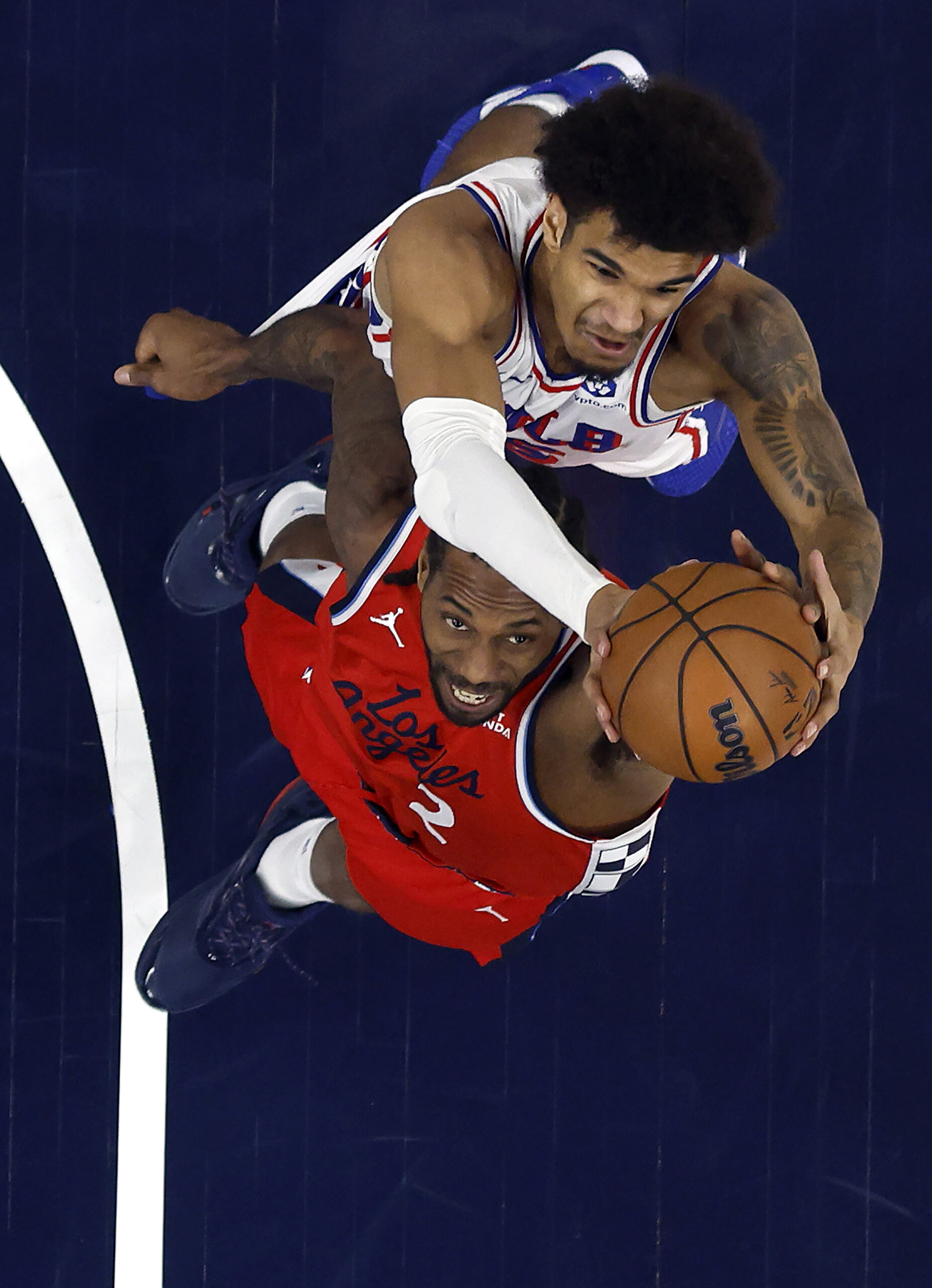 The Philadelphia 76ers’ Dominick Barlow, top, and Clippers star Kawhi...